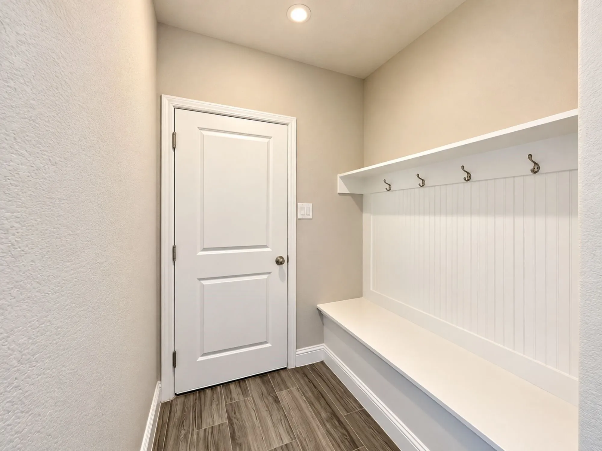 Built-in bench with beadboard backing, an integrated shelf, and four coat hooks