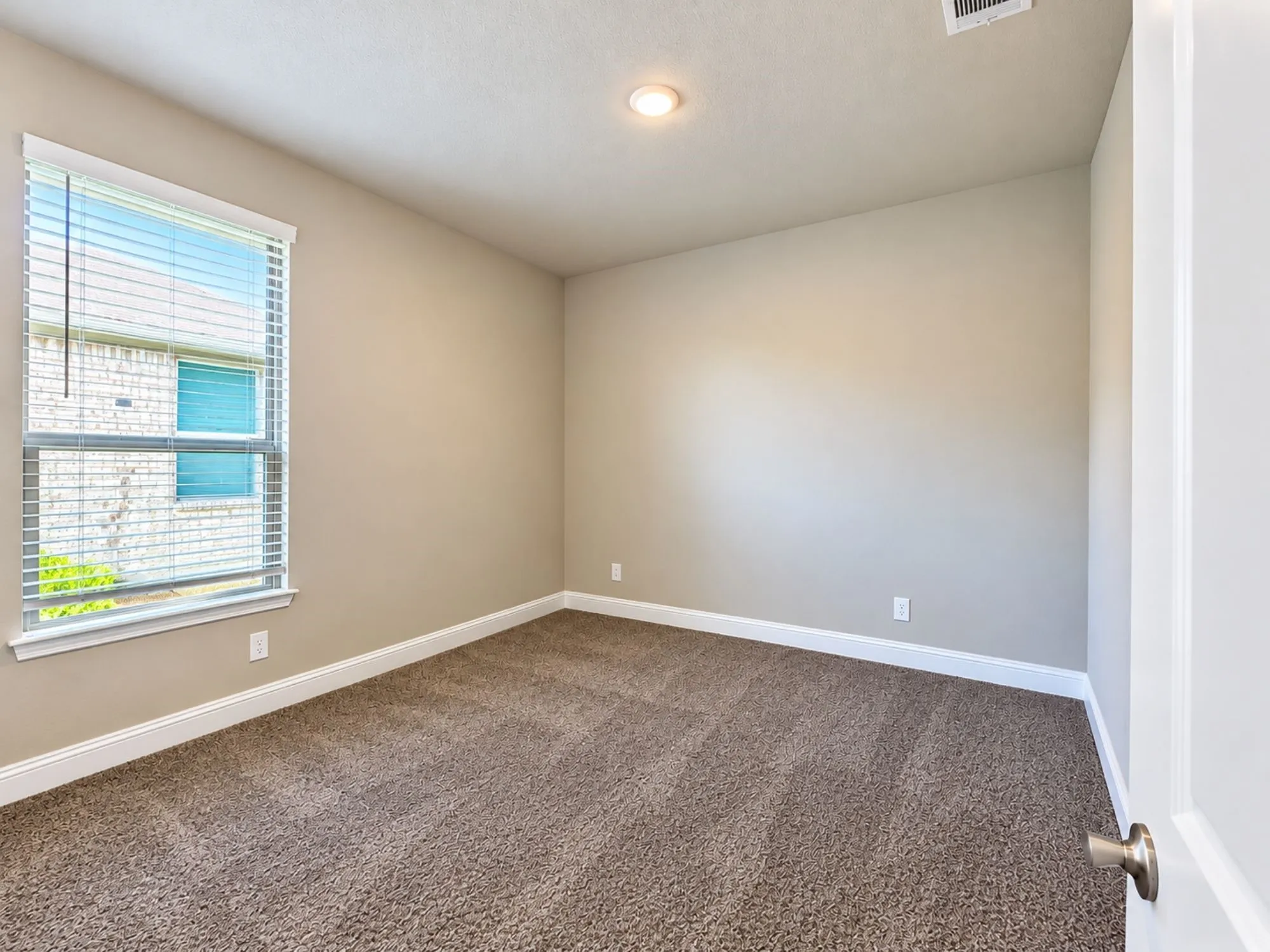 Carpeted room featuring a single window with blinds, recessed lighting, and neutral wall tones