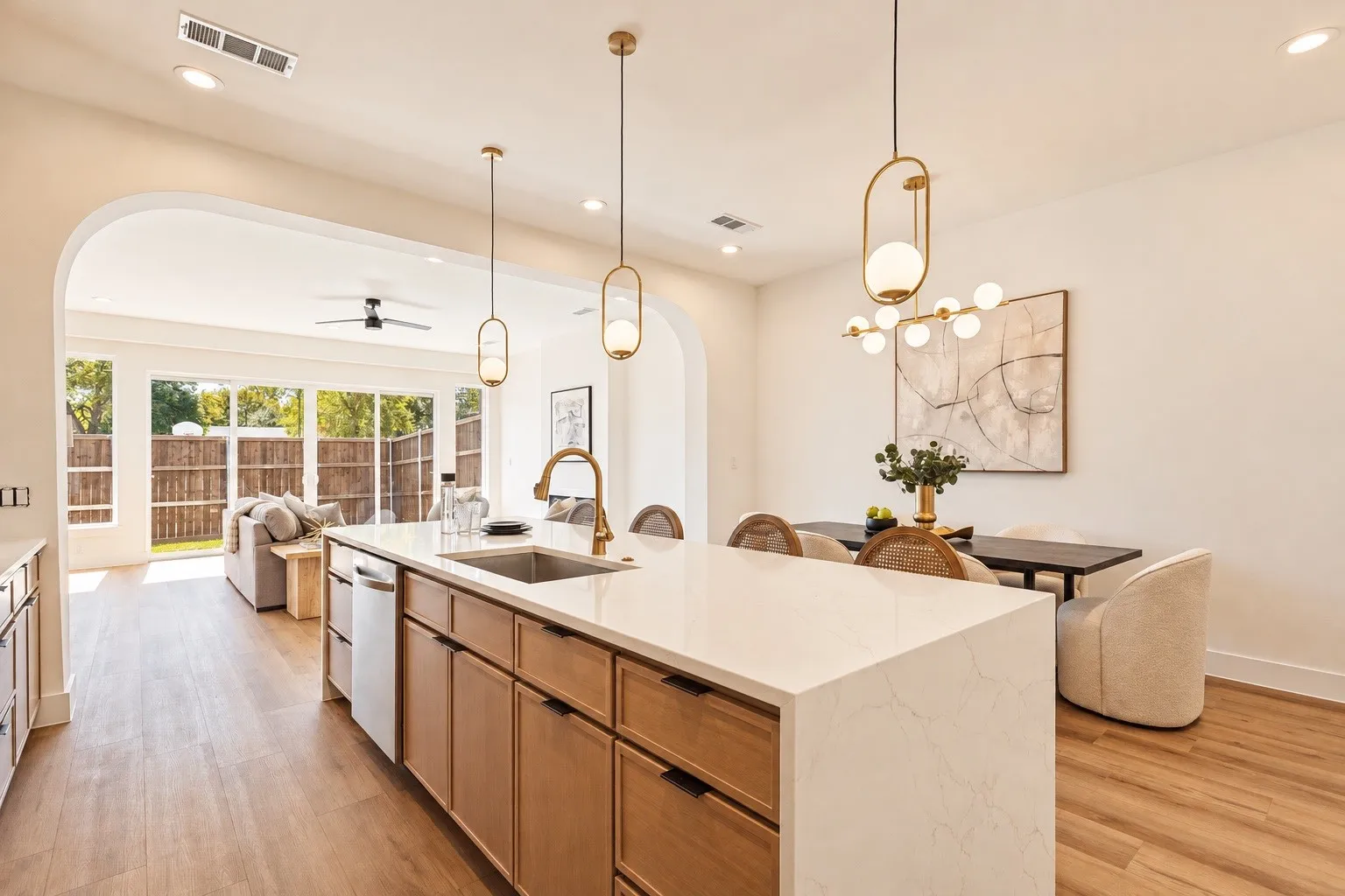 Kitchen island with built-in sink and dishwasher, featuring a light-toned countertop and wood-finish cabinetry