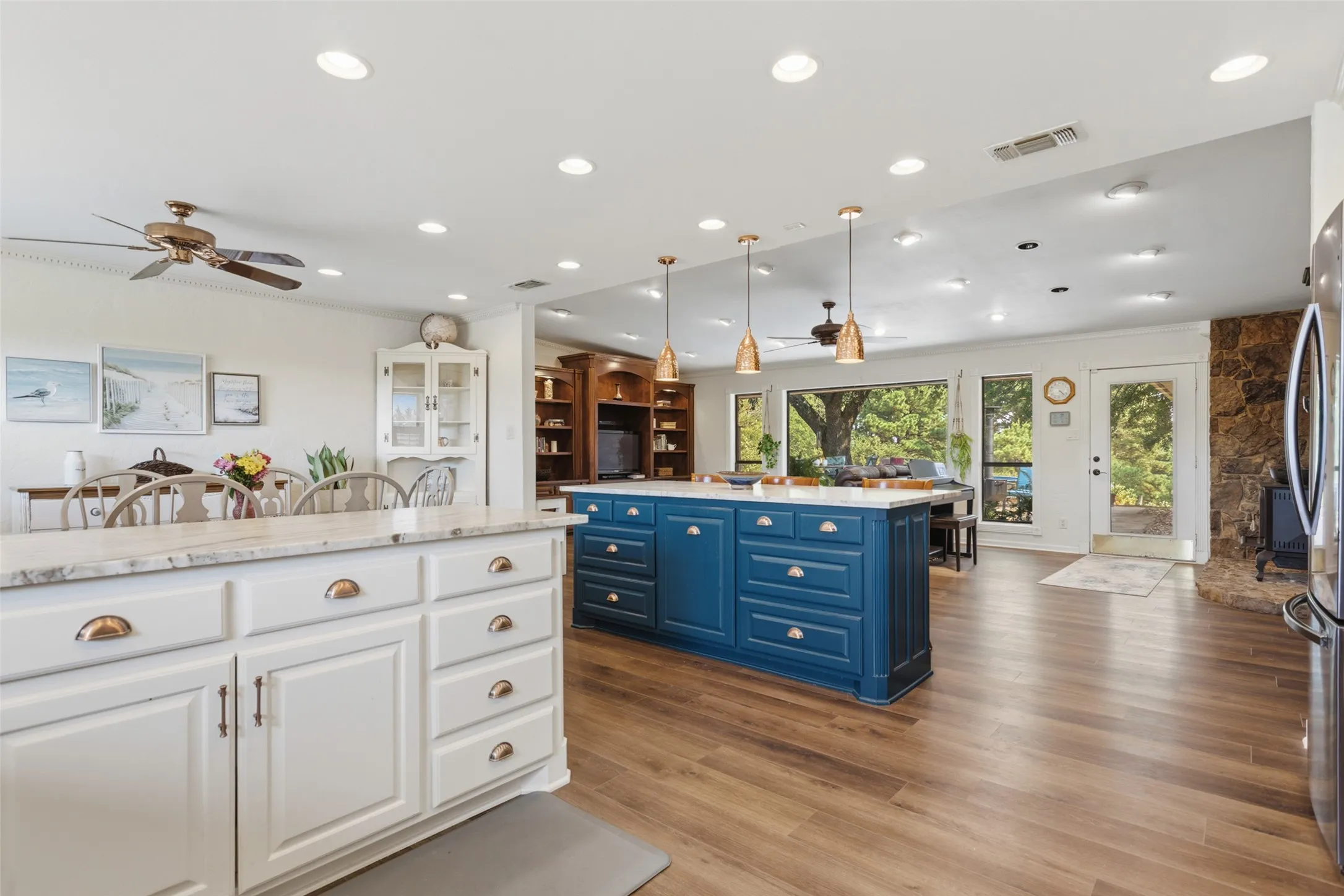 Kitchen featuring a large blue island, wood-finish flooring, recessed lighting, and a white cabinet island with a stone-finish countertop