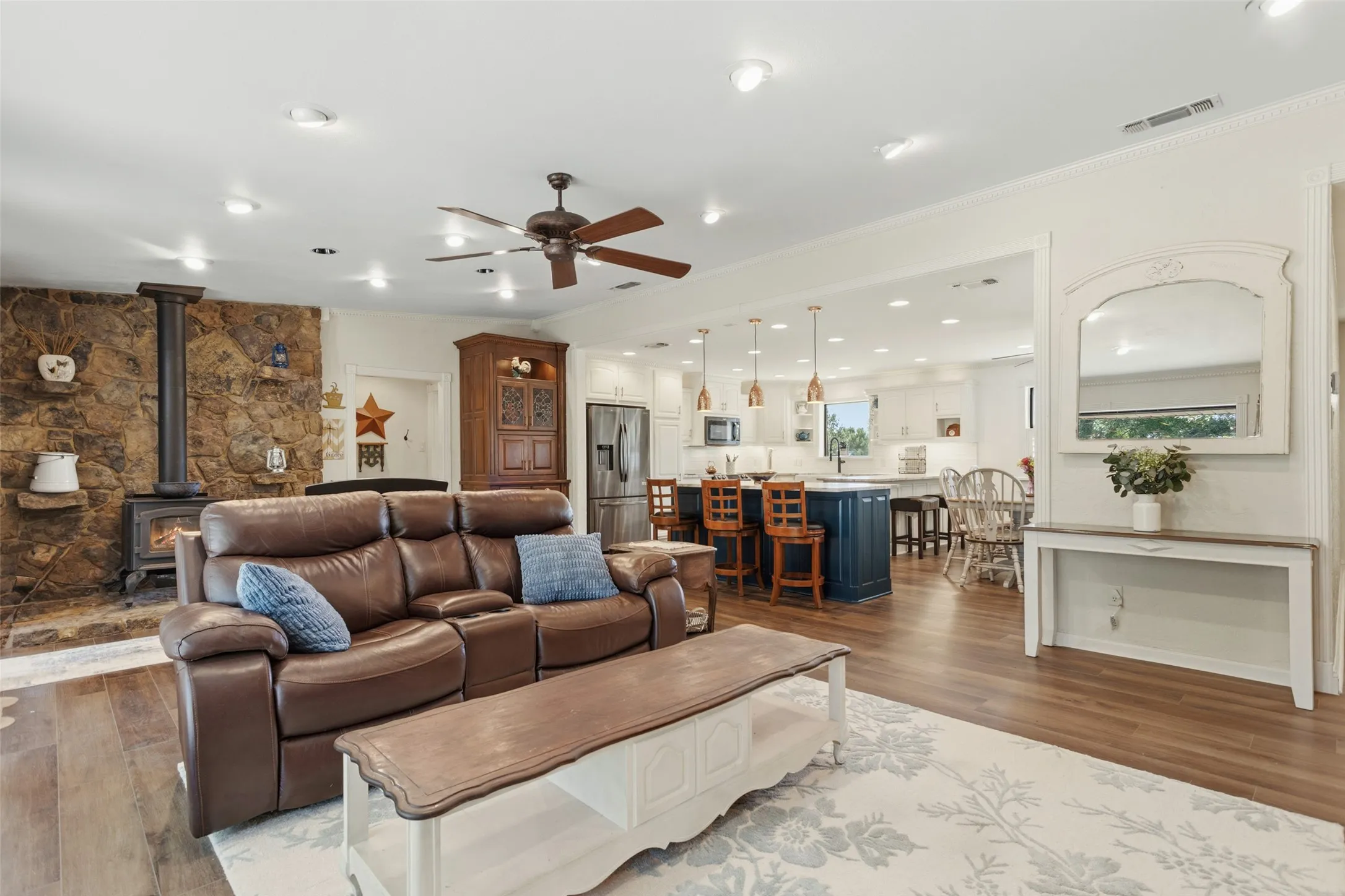 Open-concept living area featuring a wood-finish plank floor, recessed lighting, and ceiling fan
