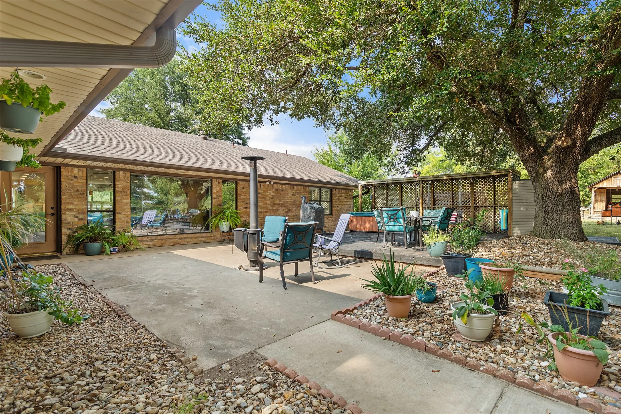 Expansive patio area featuring concrete and gravel landscaping, with a brick exterior