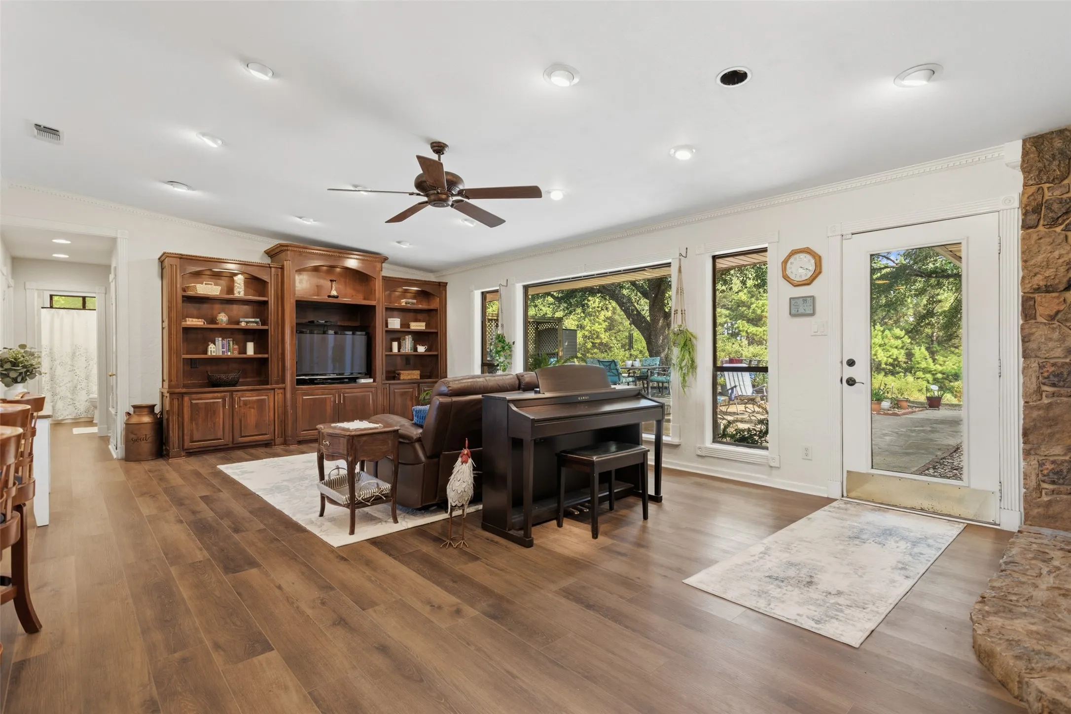 Spacious open-concept living area featuring hardwood flooring, recessed lighting, and a ceiling fan