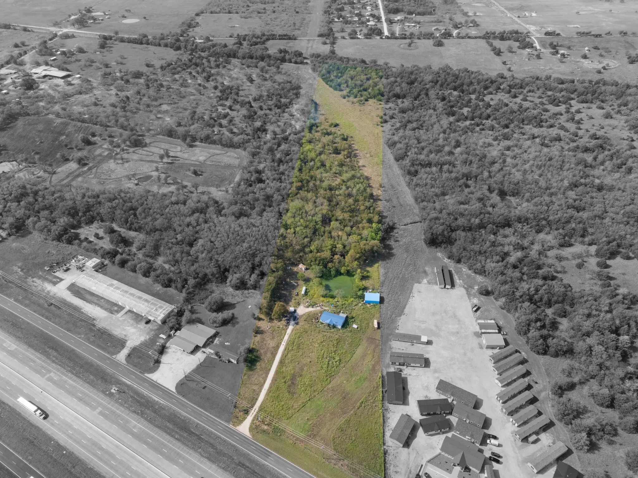 Expansive land parcel featuring wooded areas, open clearings, and a direct frontage along the highway