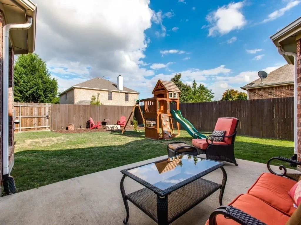 Private backyard featuring a concrete patio, wood privacy fence, and manicured lawn
