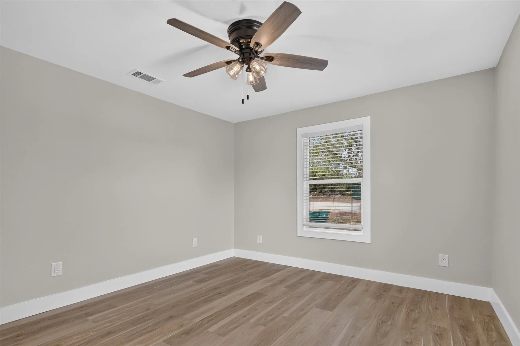 Wood-finish flooring, light grey wall paint, and white trim