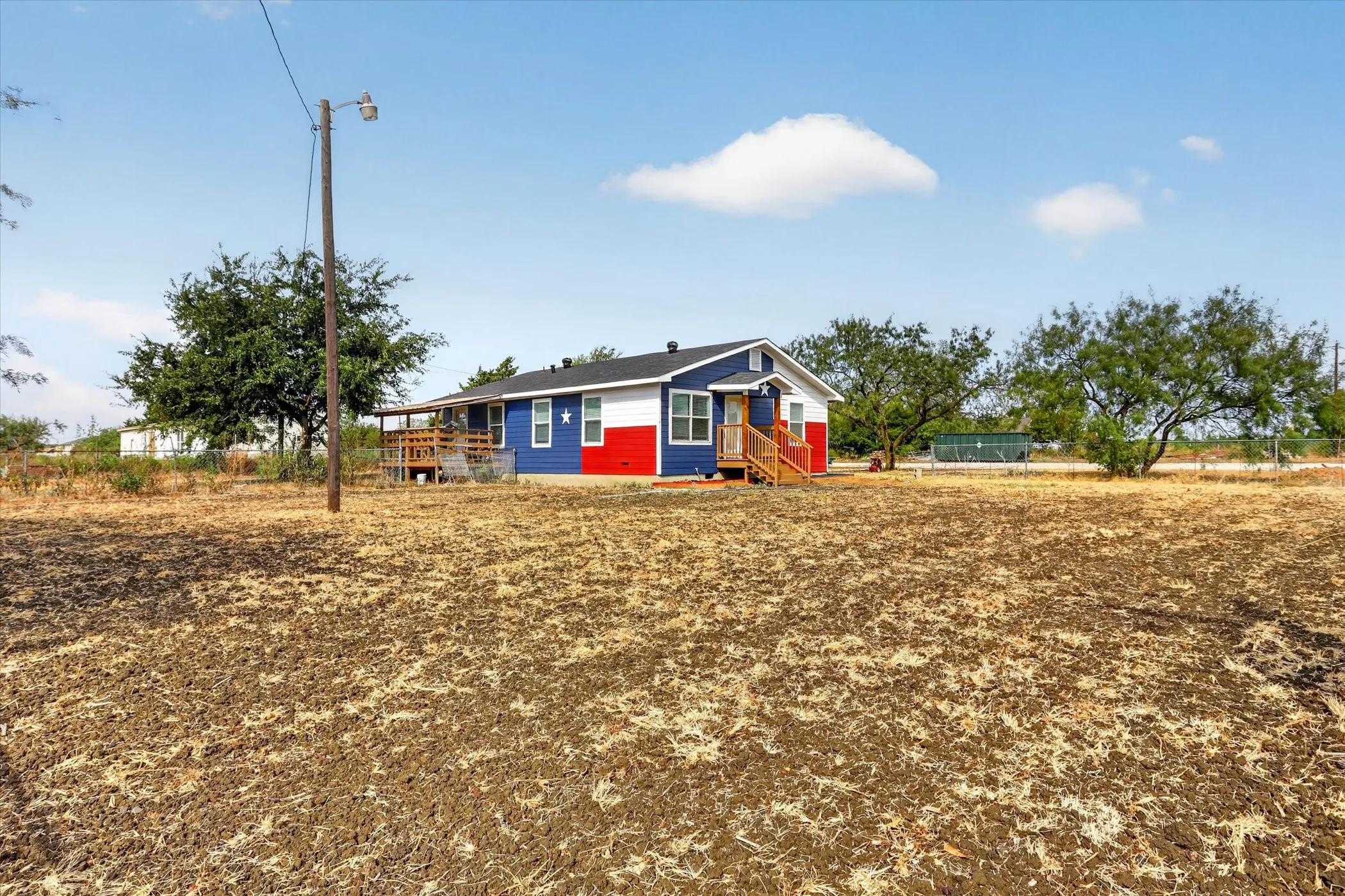 Single-story residence featuring a distinctive exterior, a covered porch, and a rear deck