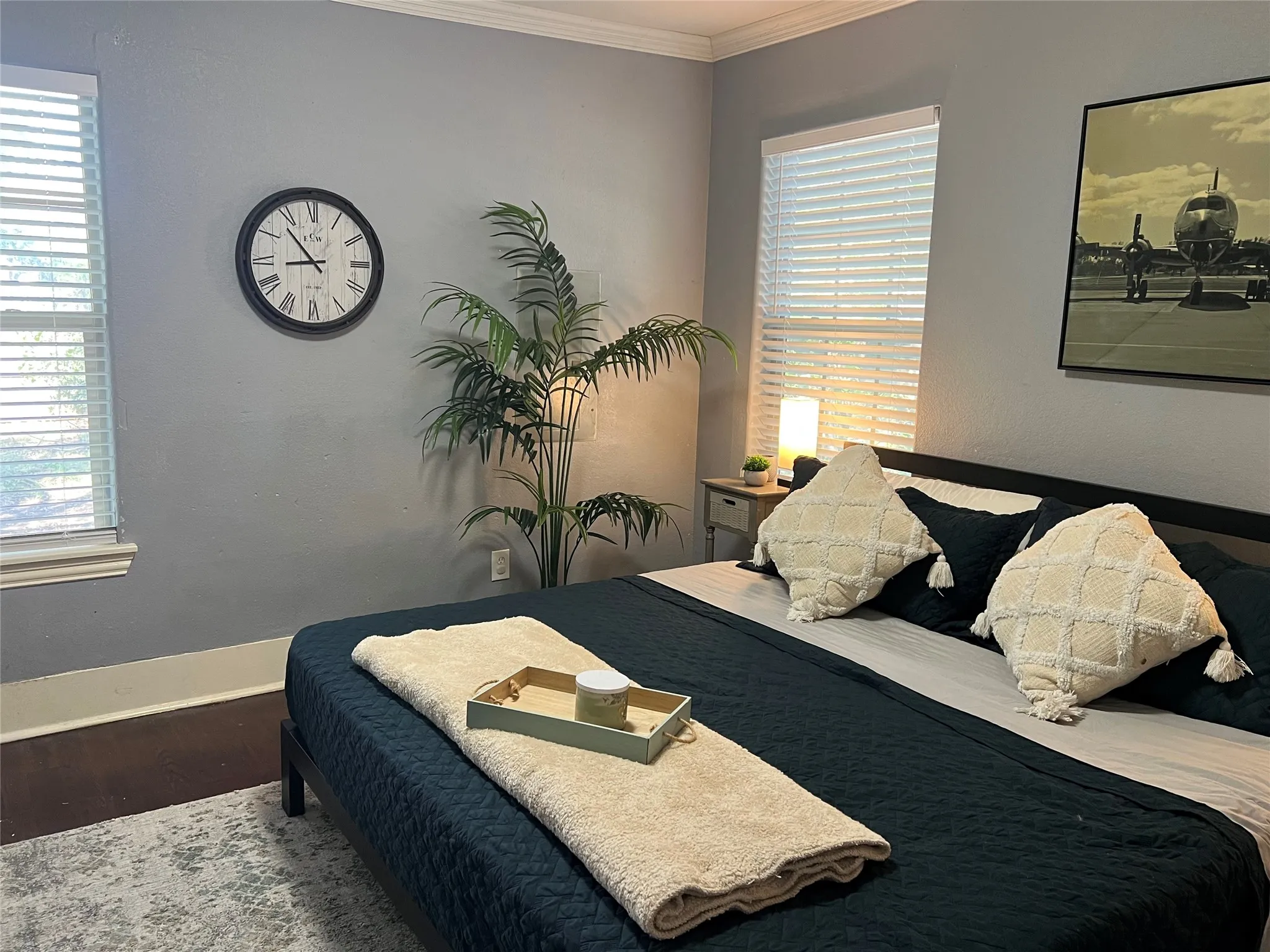 Wood-finish flooring with crown molding and two window openings