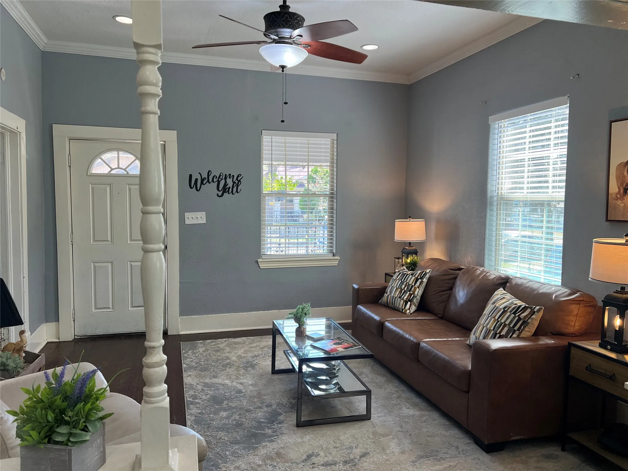 Recessed ceiling lighting, ceiling fan, crown molding, multiple windows with blinds, and wood-finish flooring