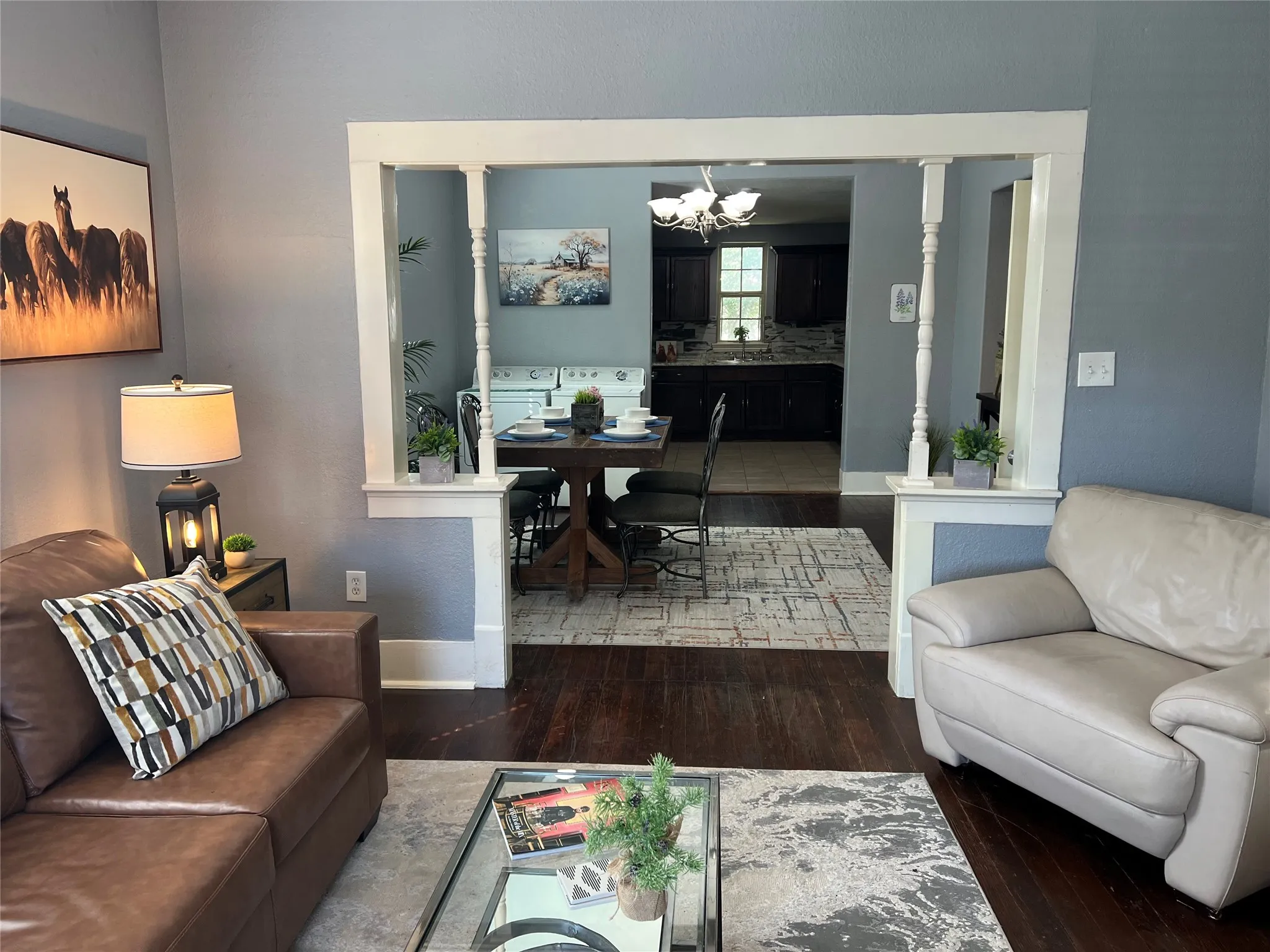 Hardwood flooring throughout, with a framed entryway featuring decorative columns