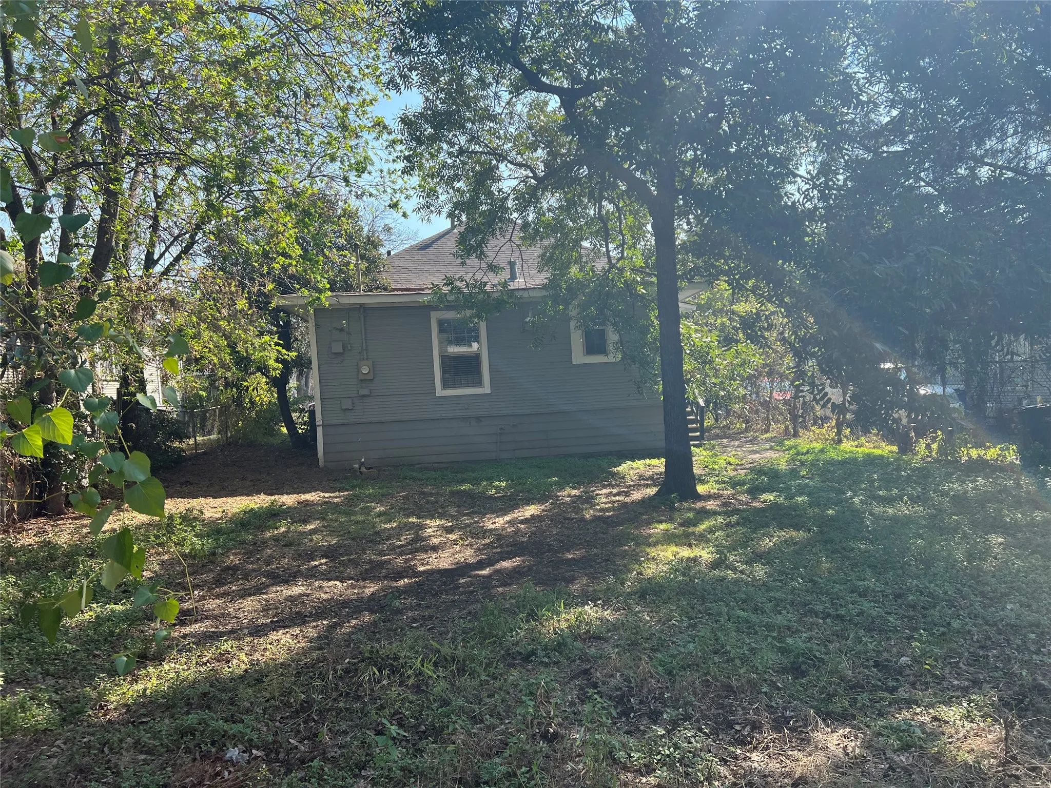 Expansive yard with mature trees and a detached structure