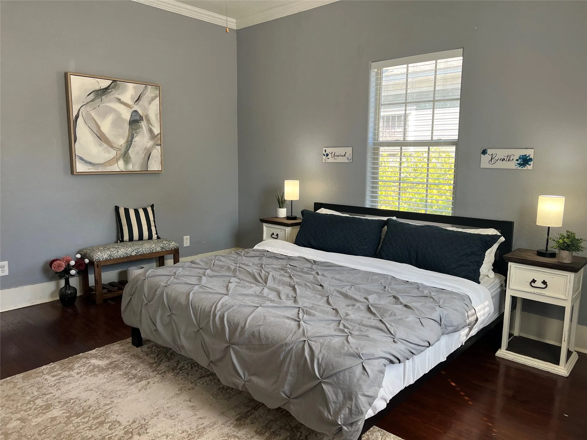 Hardwood-finish flooring, high ceilings with crown molding, and a prominent window