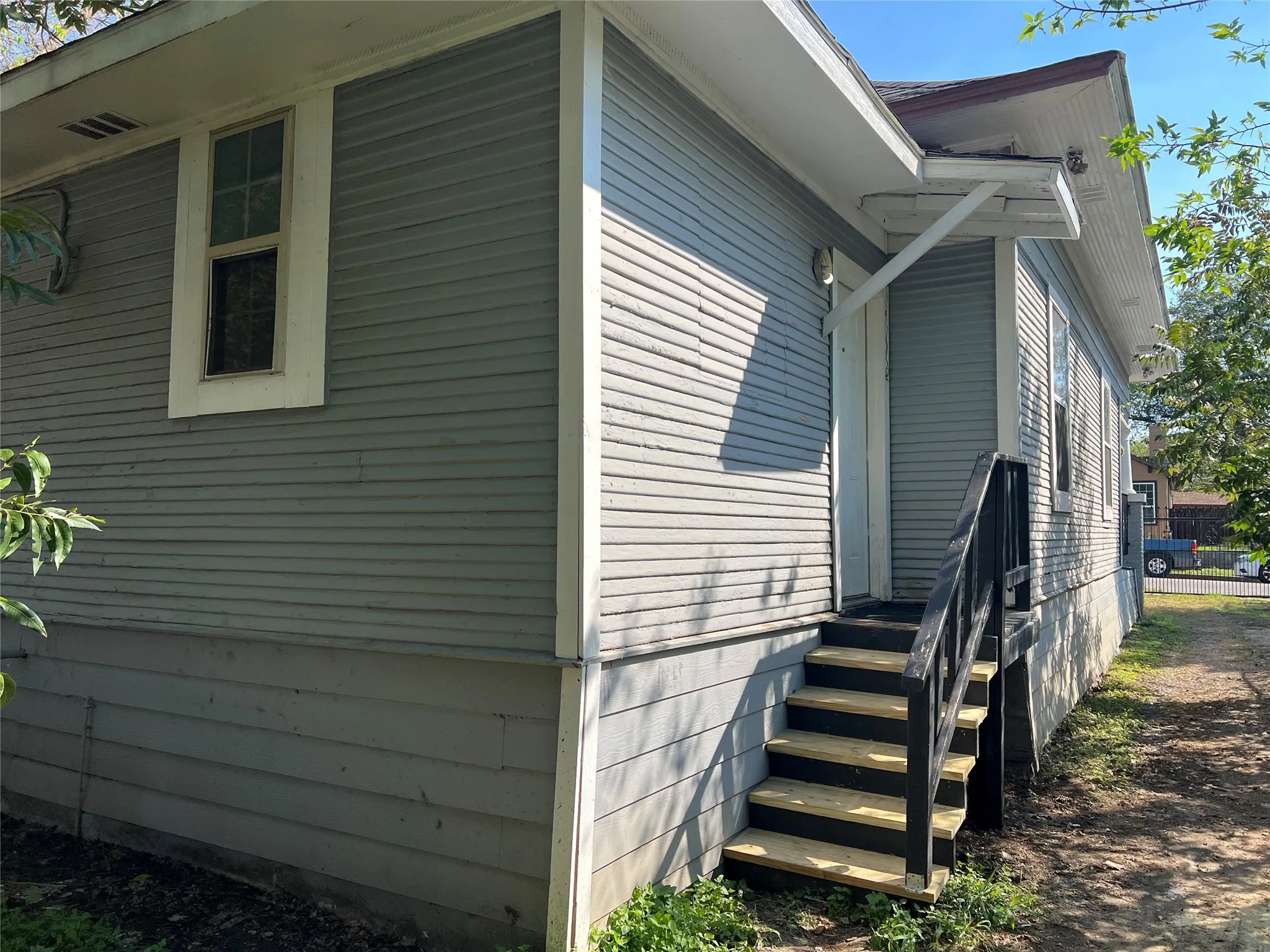 Exterior siding, multiple windows, and a multi-level exterior staircase with dark railings