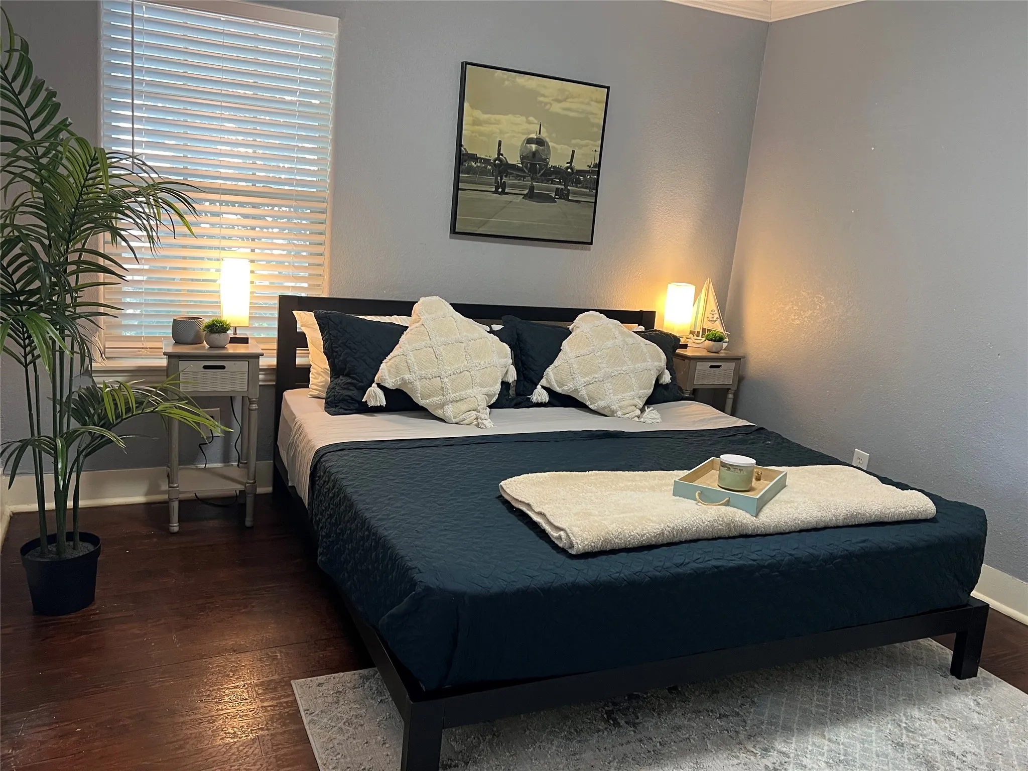 Dark wood-finish flooring, light grey painted walls, and white window blinds