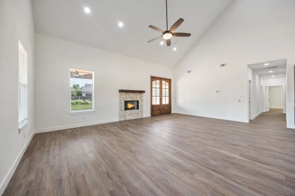 Large living room with fireplace and double doors opening out to the covered patio
