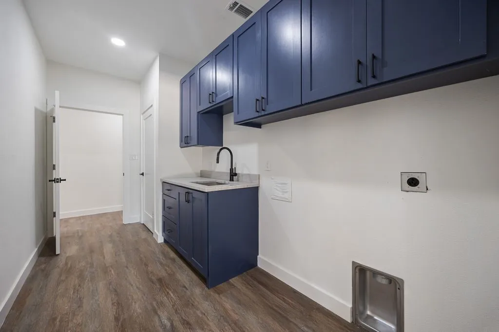 Large utility room with sink and door entrance through garage