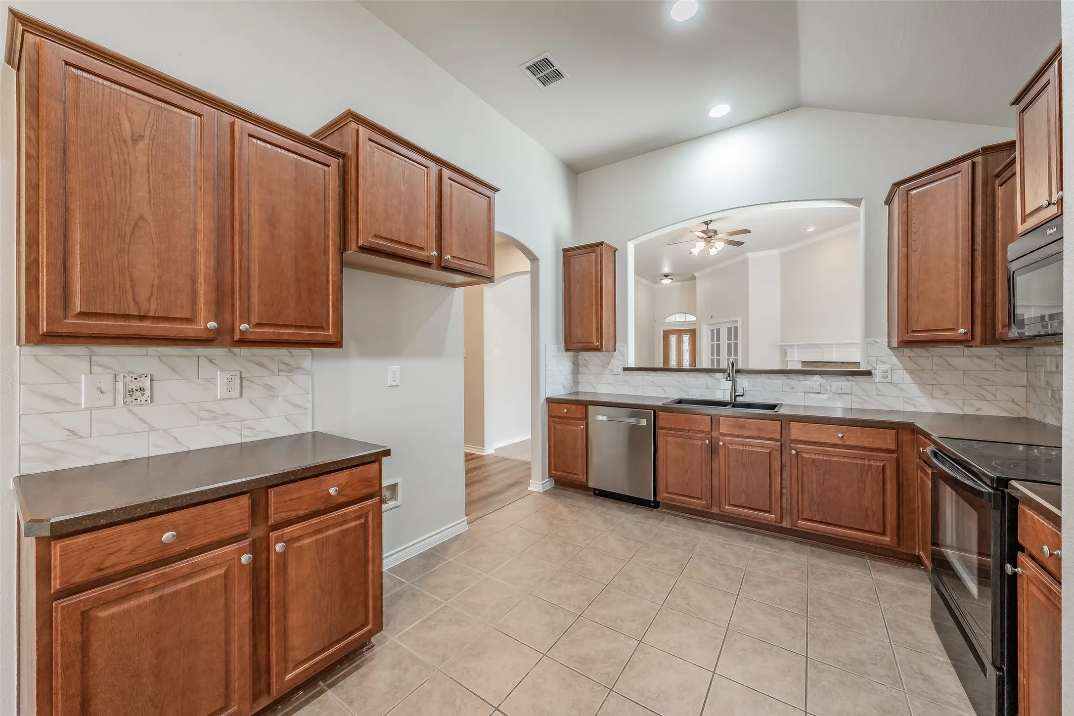 Kitchen featuring wood cabinetry, tile flooring, and stainless steel appliances