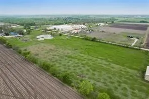Expansive acreage featuring cultivated land, a natural pond, and surrounding green spaces