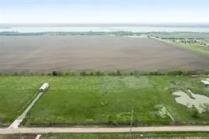 Expansive land with varied terrain, including cultivated fields and green pastures