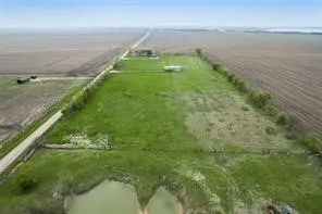 Expansive green space featuring a natural pond, a long private driveway, and clear, flat terrain