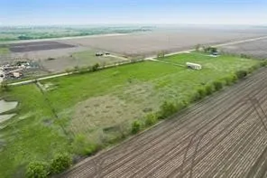 Expansive rural property featuring cultivated fields and a large open green space