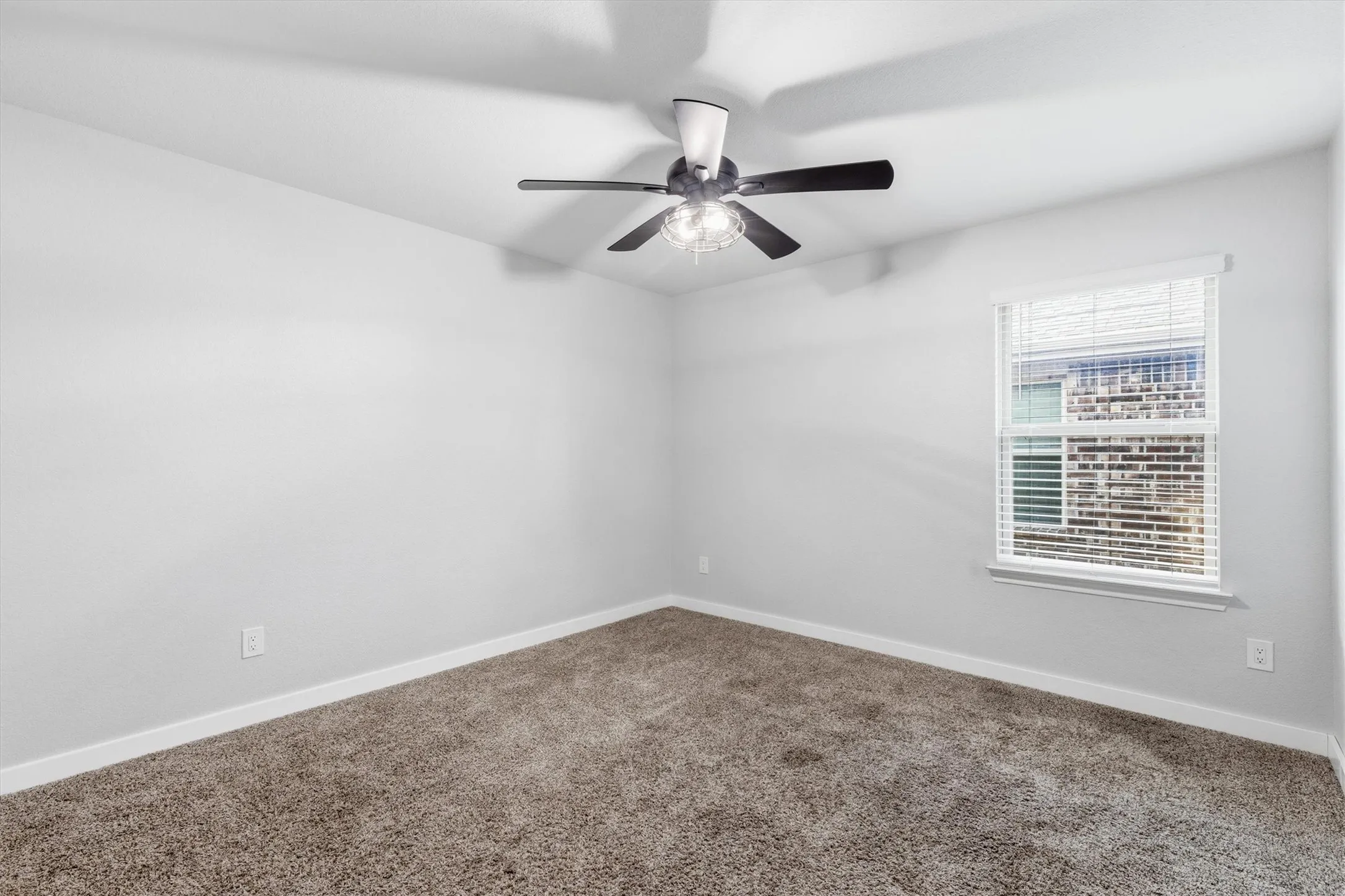Neutral tone wall paint, carpeted flooring, window with blinds, and ceiling fan with lighting