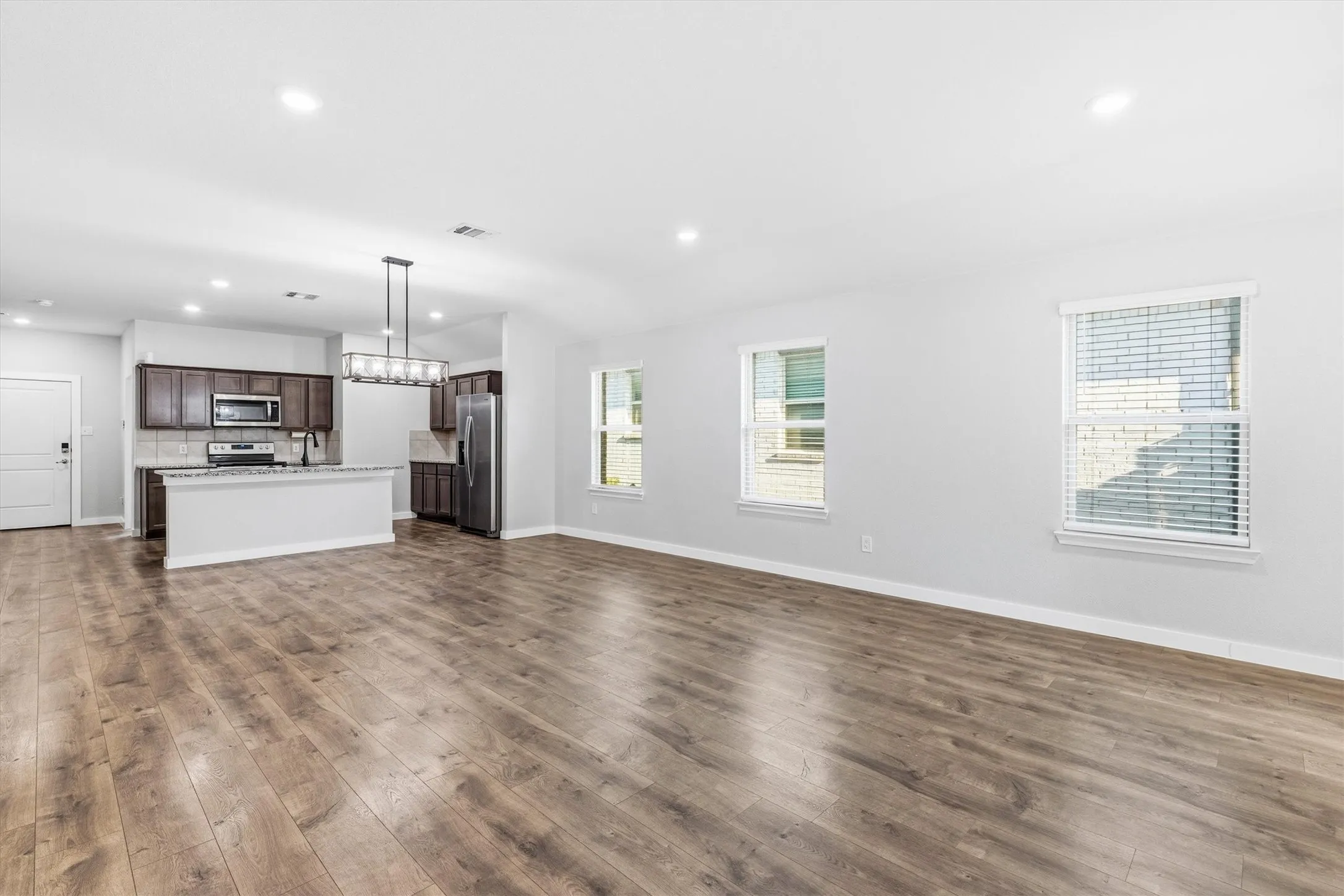 Spacious interior with wood-finish flooring, recessed lighting, and multiple windows