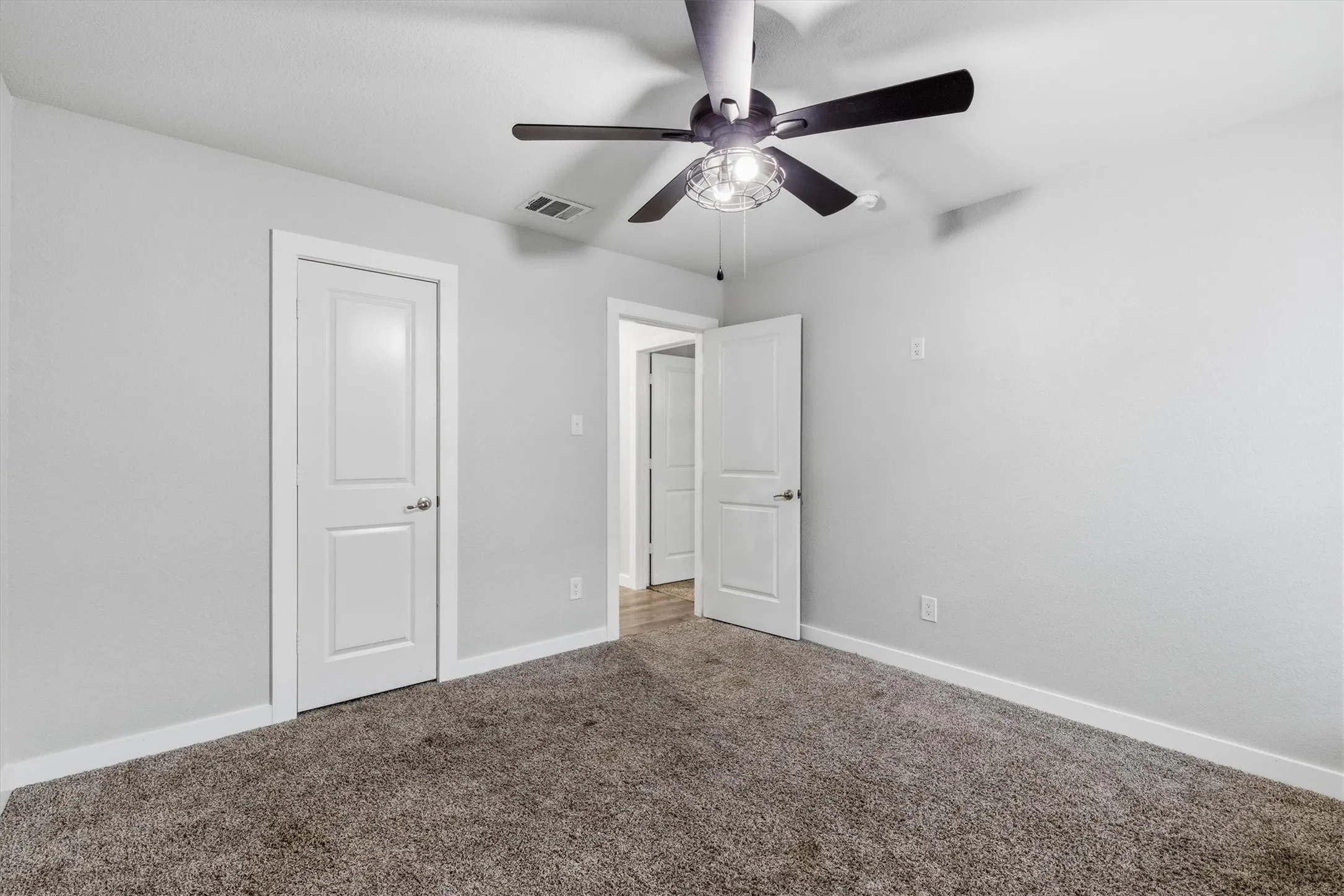 Carpeted flooring, contemporary ceiling fan with integrated lighting, and white paneled doors