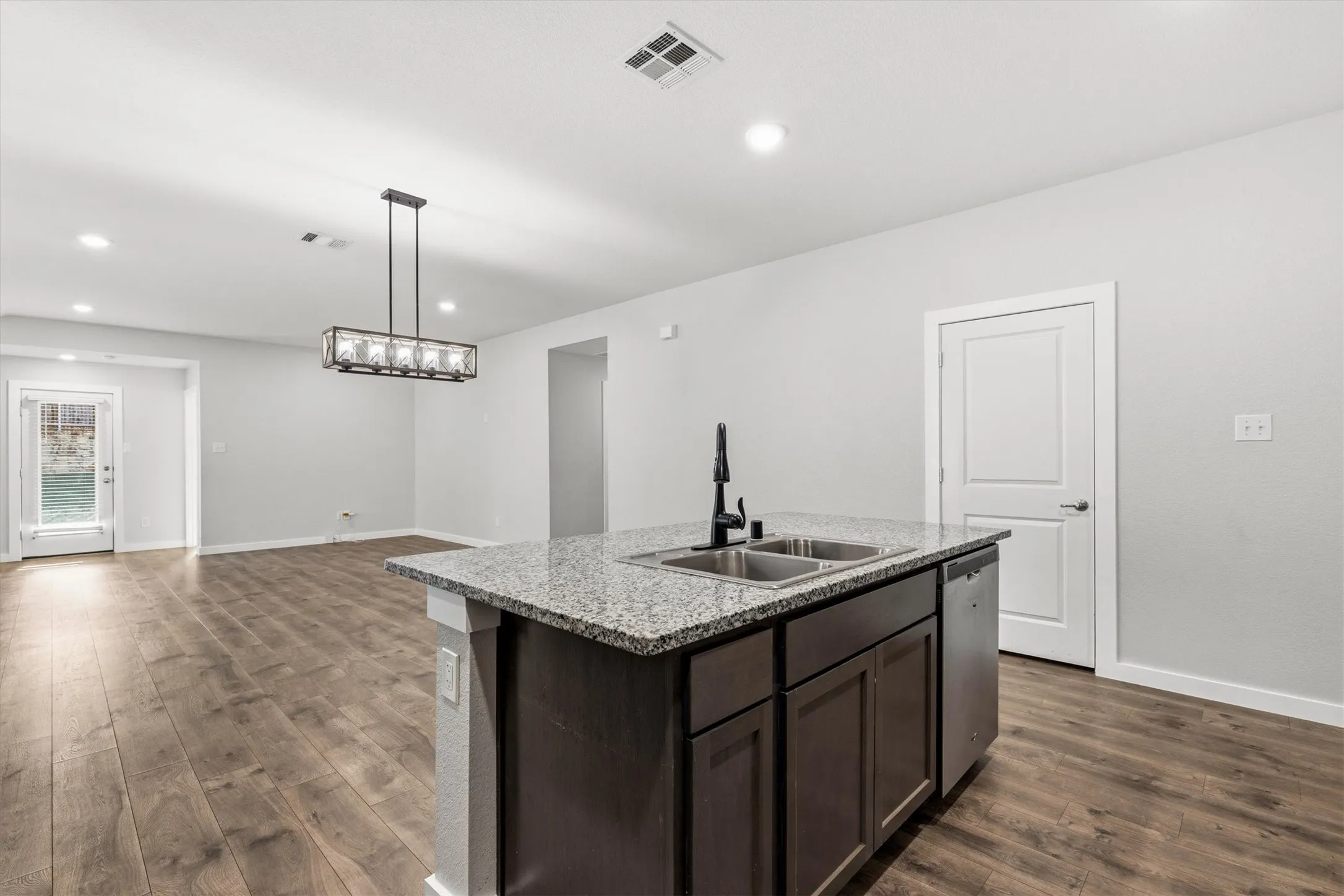 Kitchen island featuring a double-basin sink, black faucet, and stainless steel dishwasher