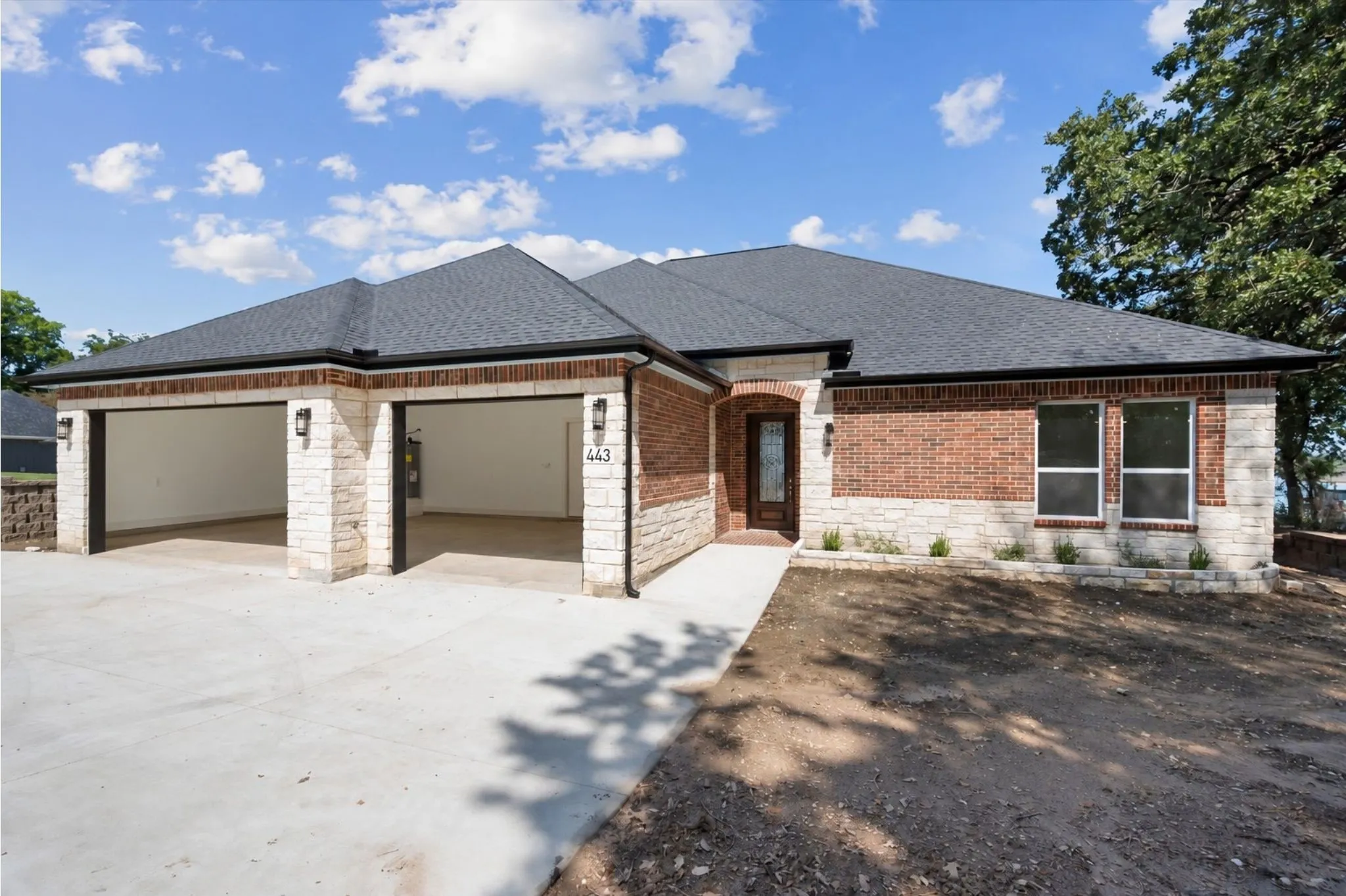 Close-up view of the front exterior displaying custom brickwork, stone accents, and an arched glass front entryway.