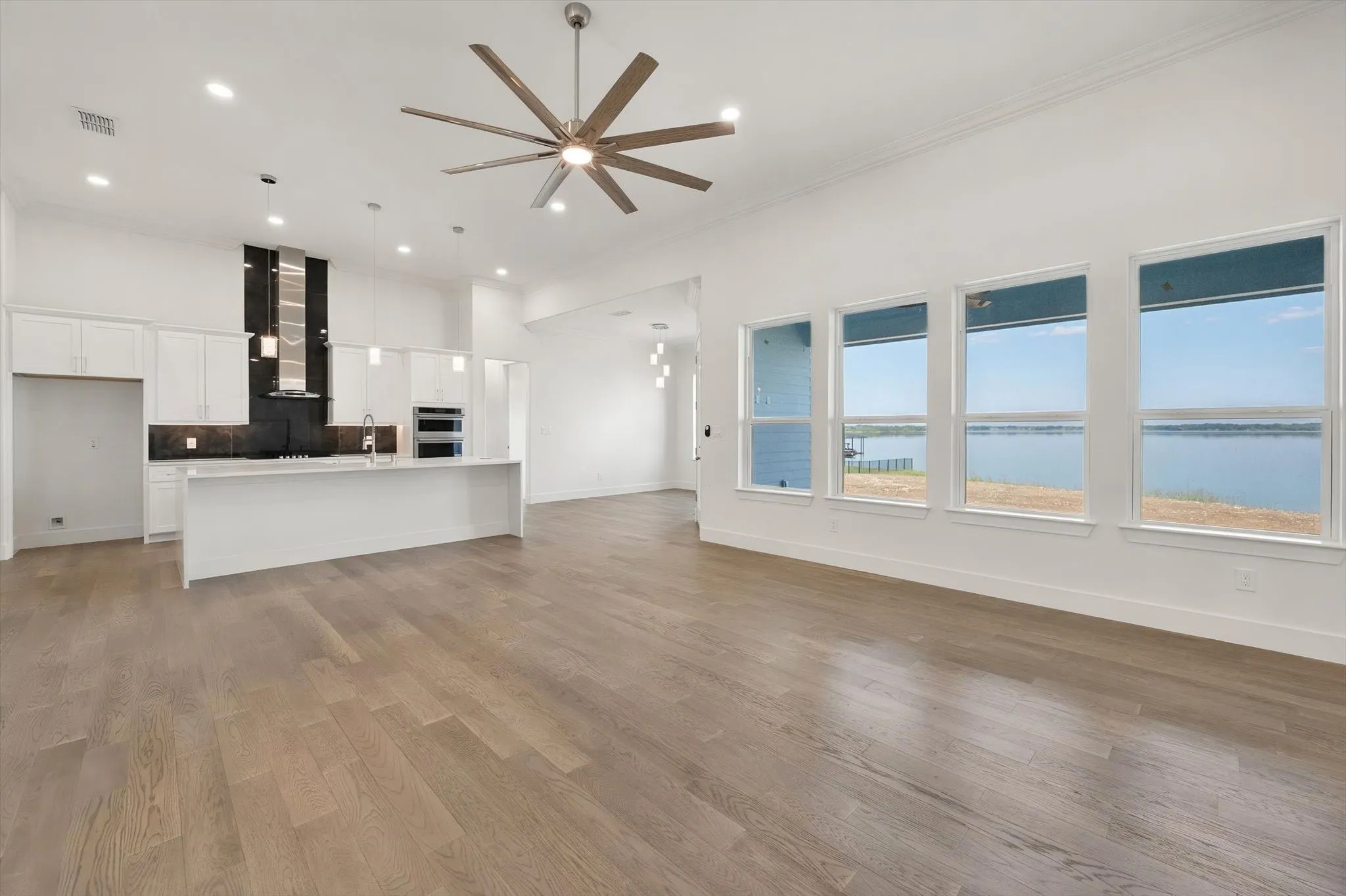 Bright open-concept living area with floor-to-ceiling windows offering expansive views of Richland Chambers Lake.