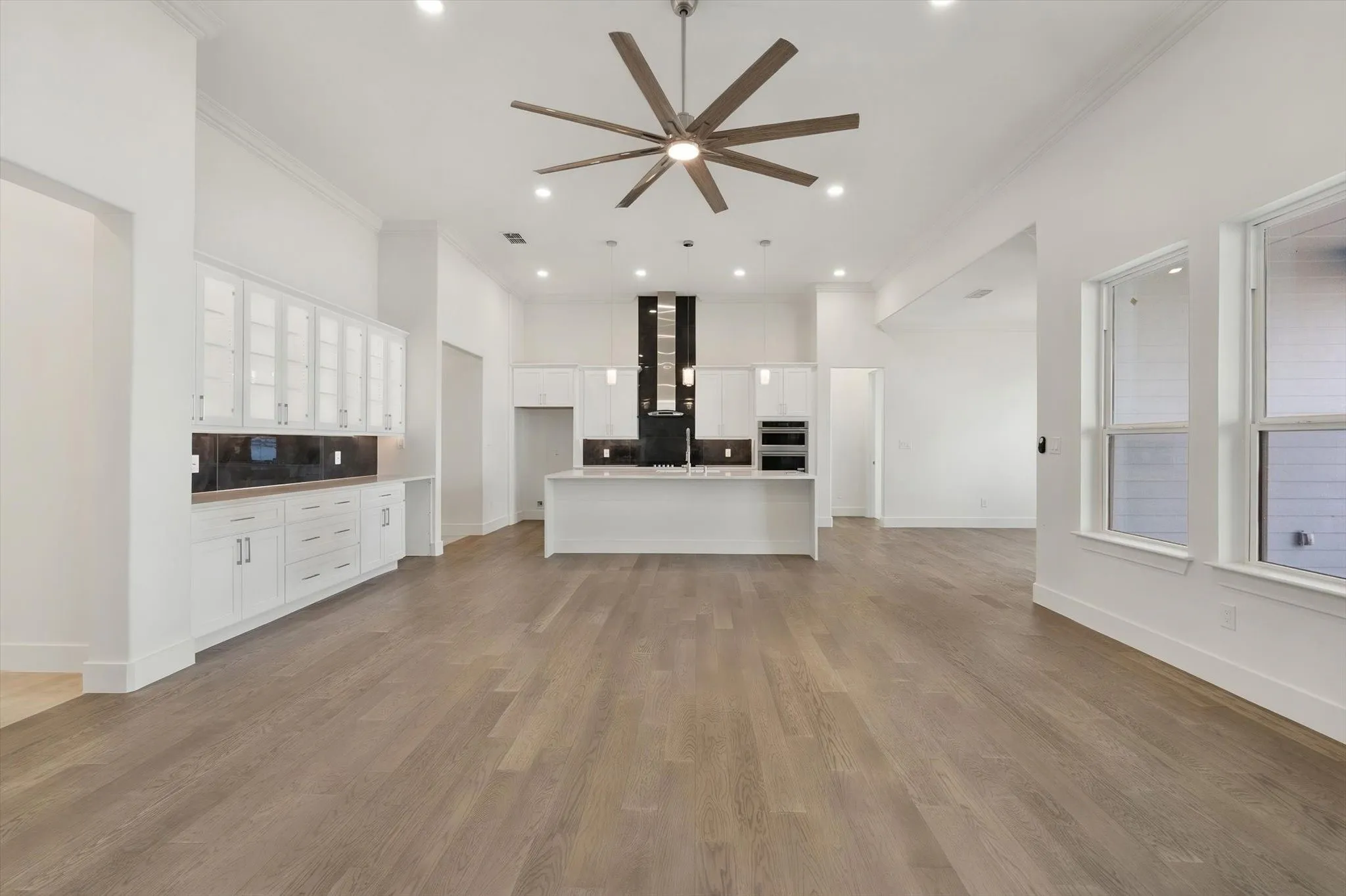 Expansive main living room offering a seamlessly integrated floor plan with custom built-in cabinetry and direct kitchen access.