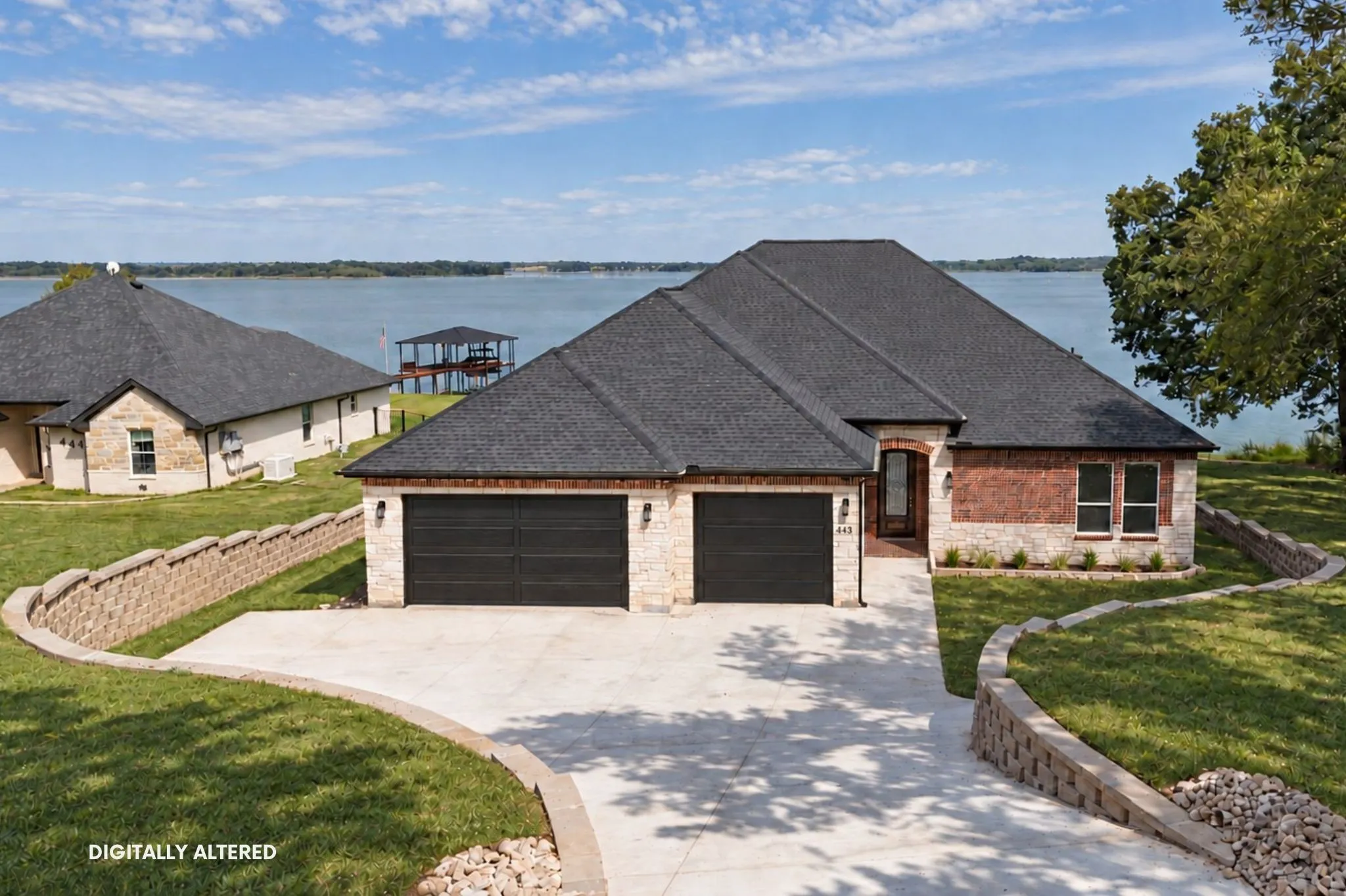 Digitally Altered showing builder's intended garage door installation and grass lawn. Estimated date of completion 10/30/26.  An elevated front view of 443 in Bluffview Lake Estates, Corsicana, TX, featuring brick and stone masonry, a curved concrete driveway, and lake views.