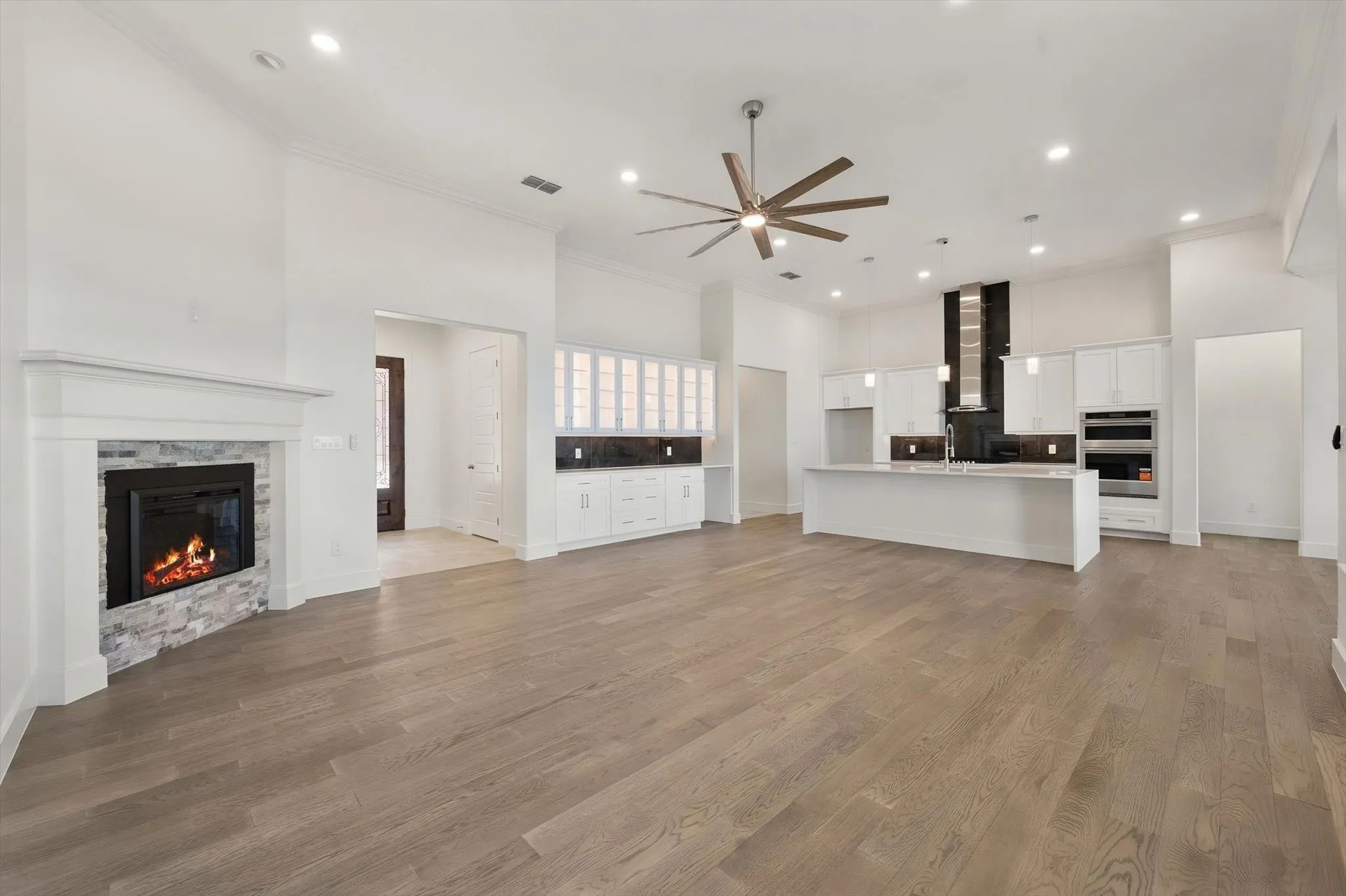 Comprehensive interior view of this Bluffview Lake Estates home in Corsicana, TX, showing the seamless flow between fireplace, living, and kitchen.