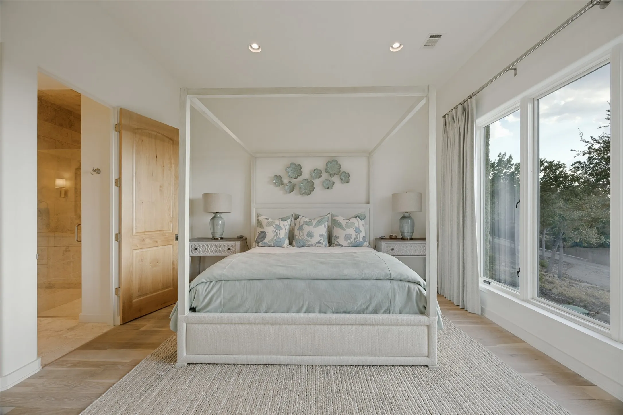 Recessed lighting, wood-finish flooring, natural wood door, and large windows