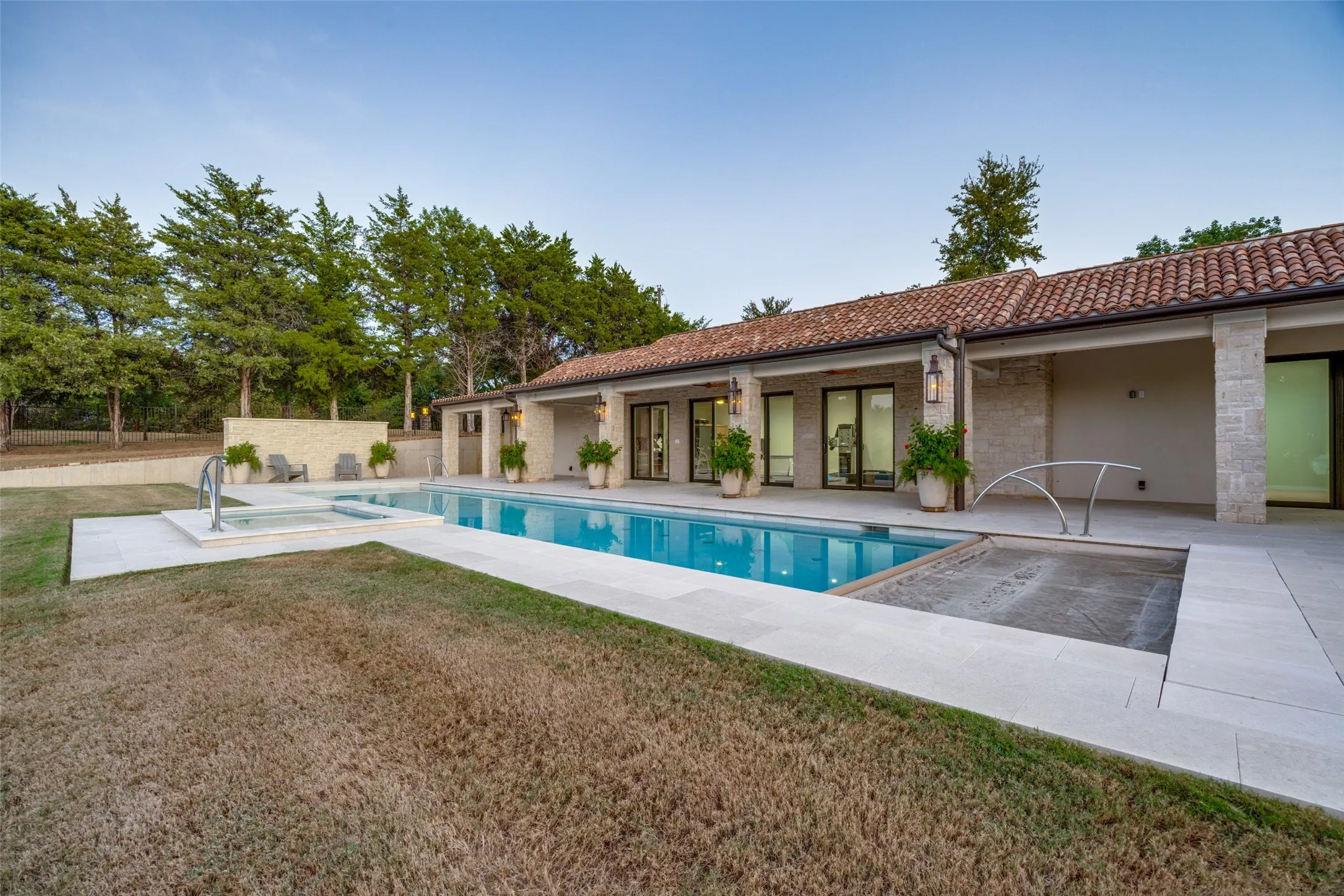Terracotta tile roof, stone exterior, inground swimming pool, integrated spa, and extensive patio decking