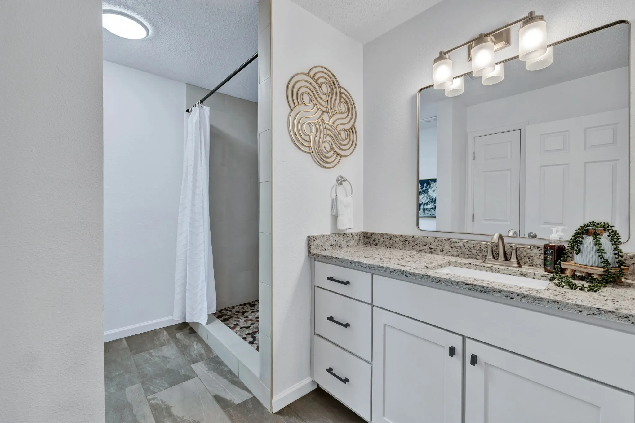 Bathroom featuring a double vanity with stone countertop, undermount sink, and brushed nickel fixtures