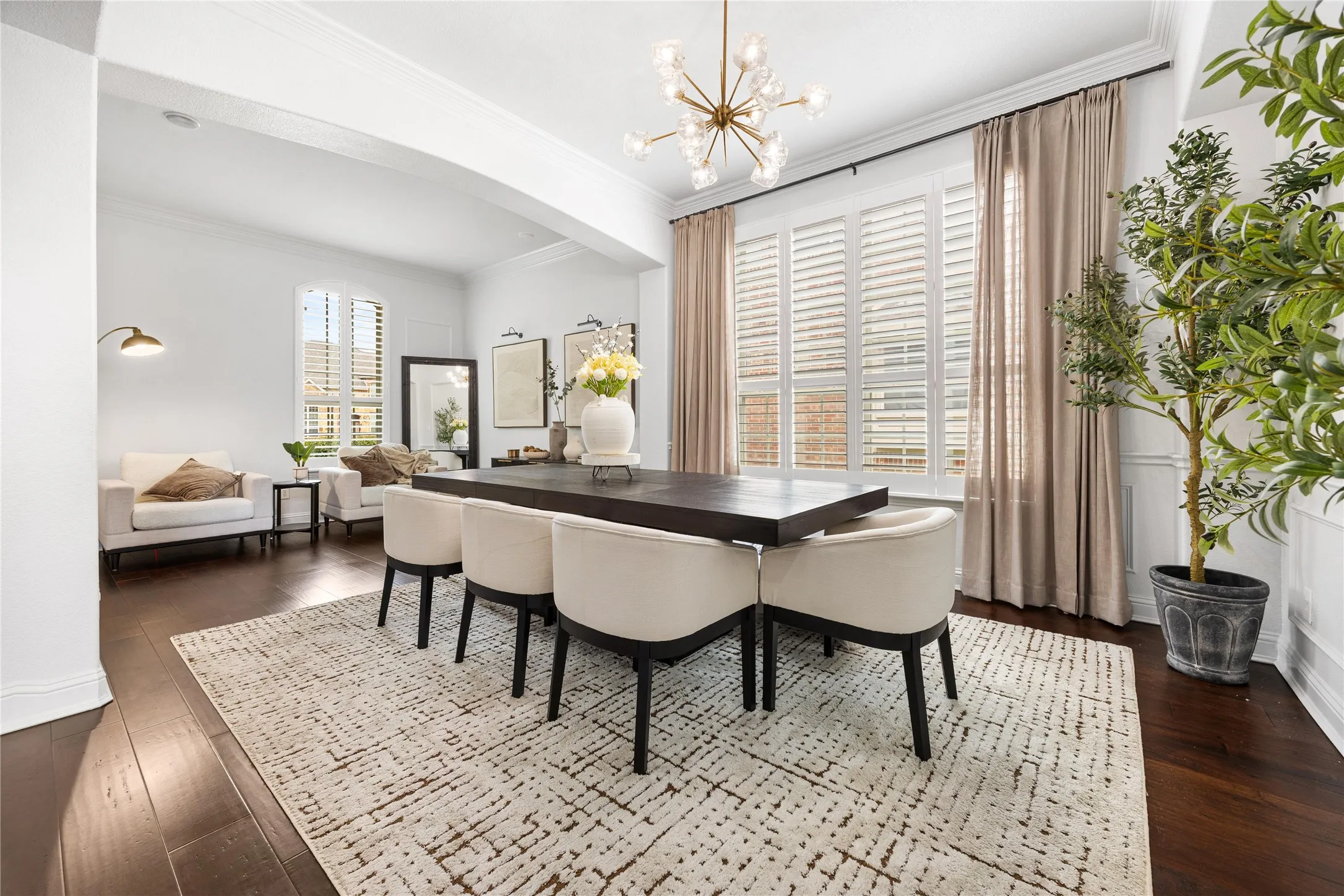 Hardwood-style flooring, white crown molding, recessed lighting, white window shutters, and a contemporary chandelier