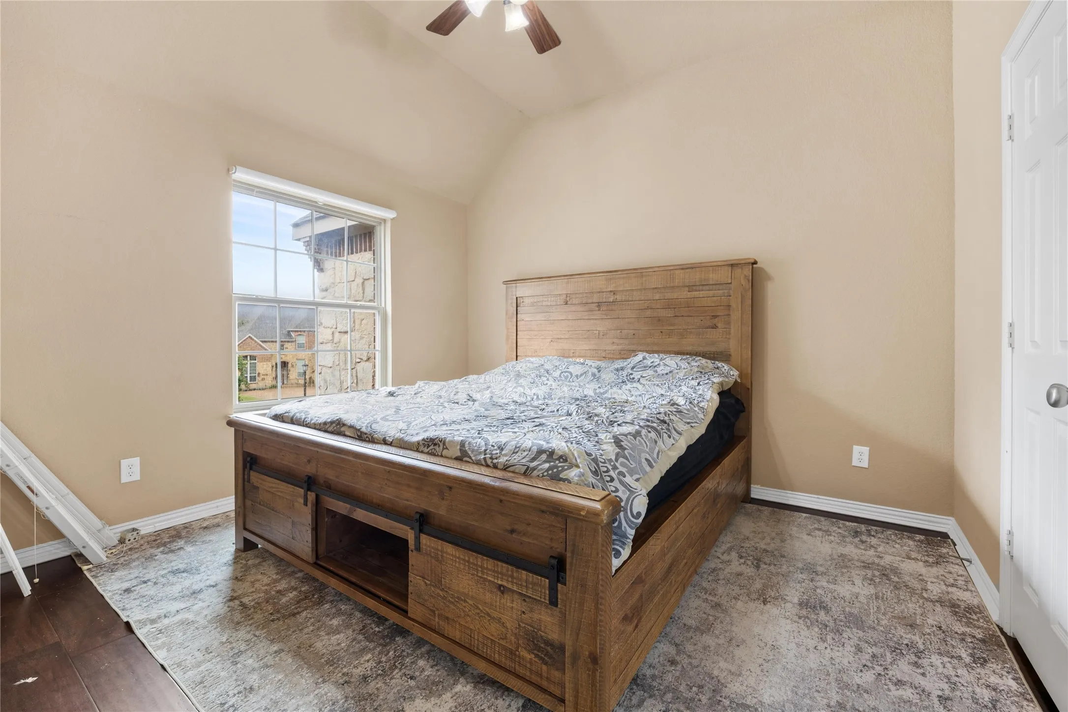 Vaulted ceiling with a ceiling fan, window with white blinds, and dark wood-finish flooring