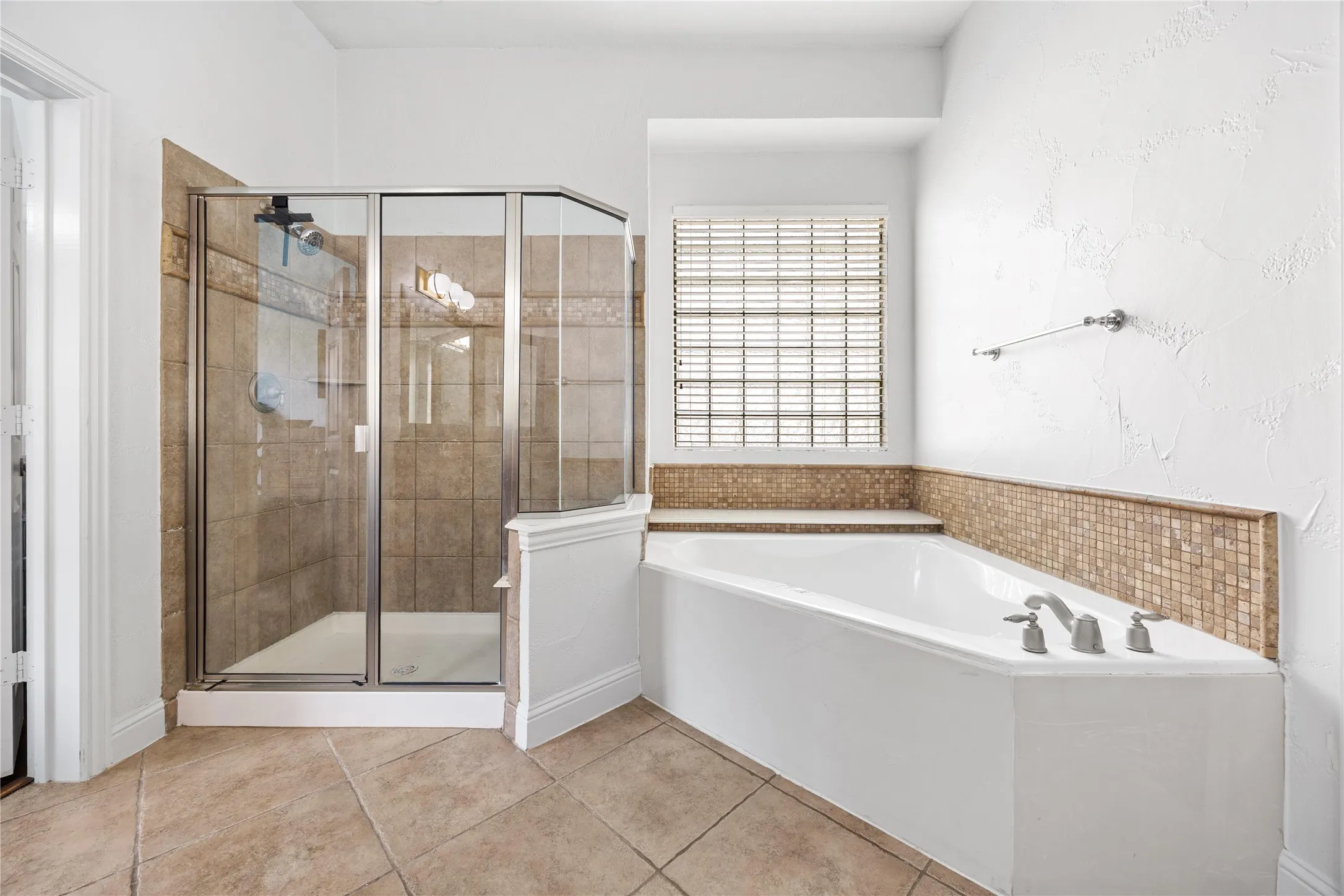 Tiled flooring complementing the shower and bathtub surrounds