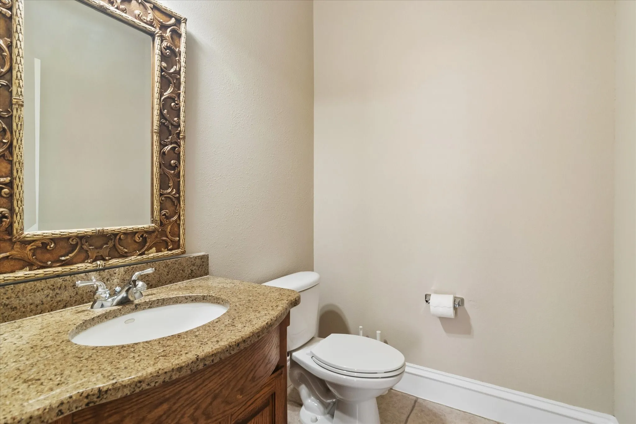 Vanity with granite countertop, integrated sink, and wood-finish cabinetry