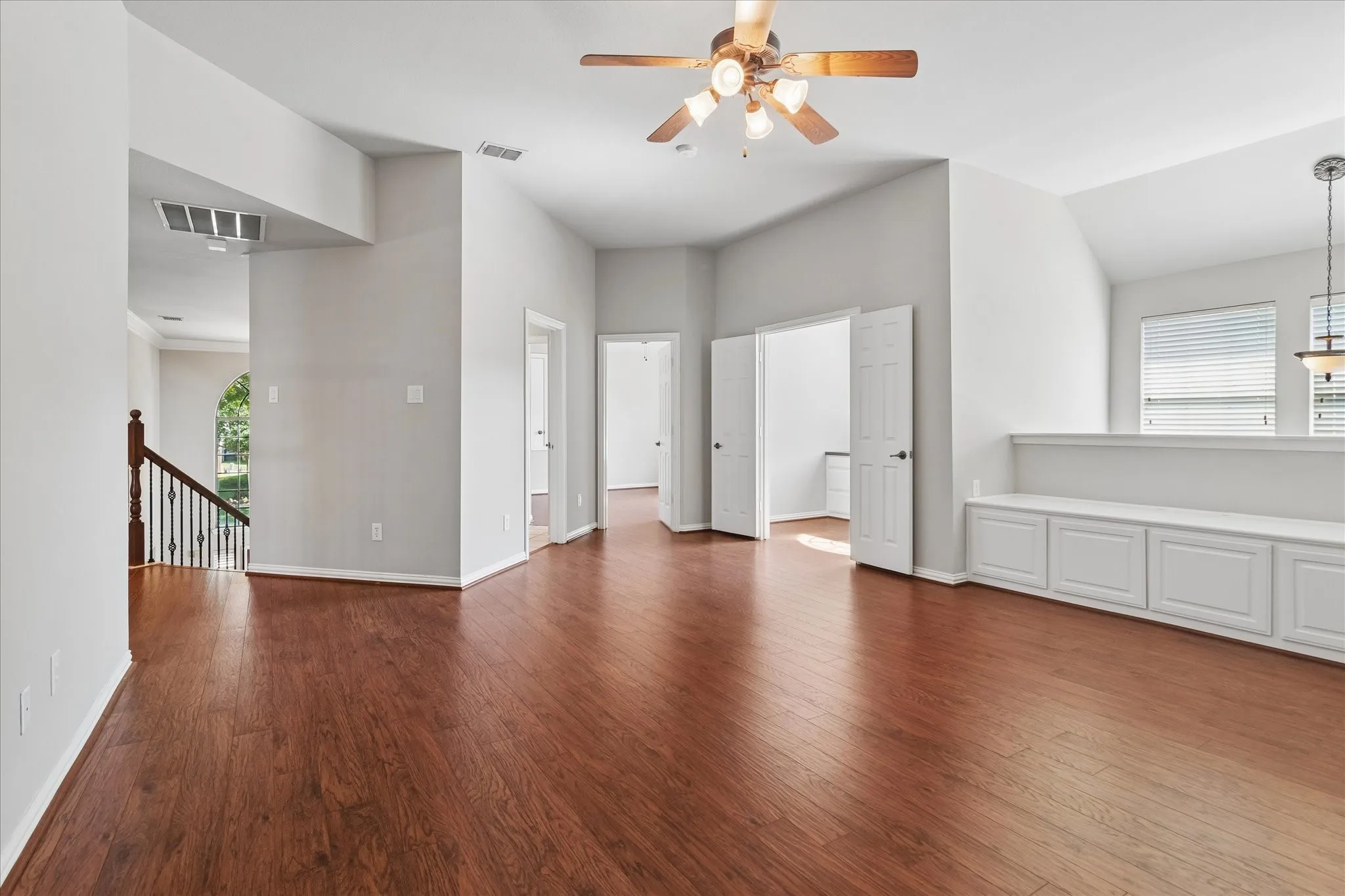 Warm wood-finish flooring, vaulted ceilings, and a built-in storage bench with panel-front cabinetry