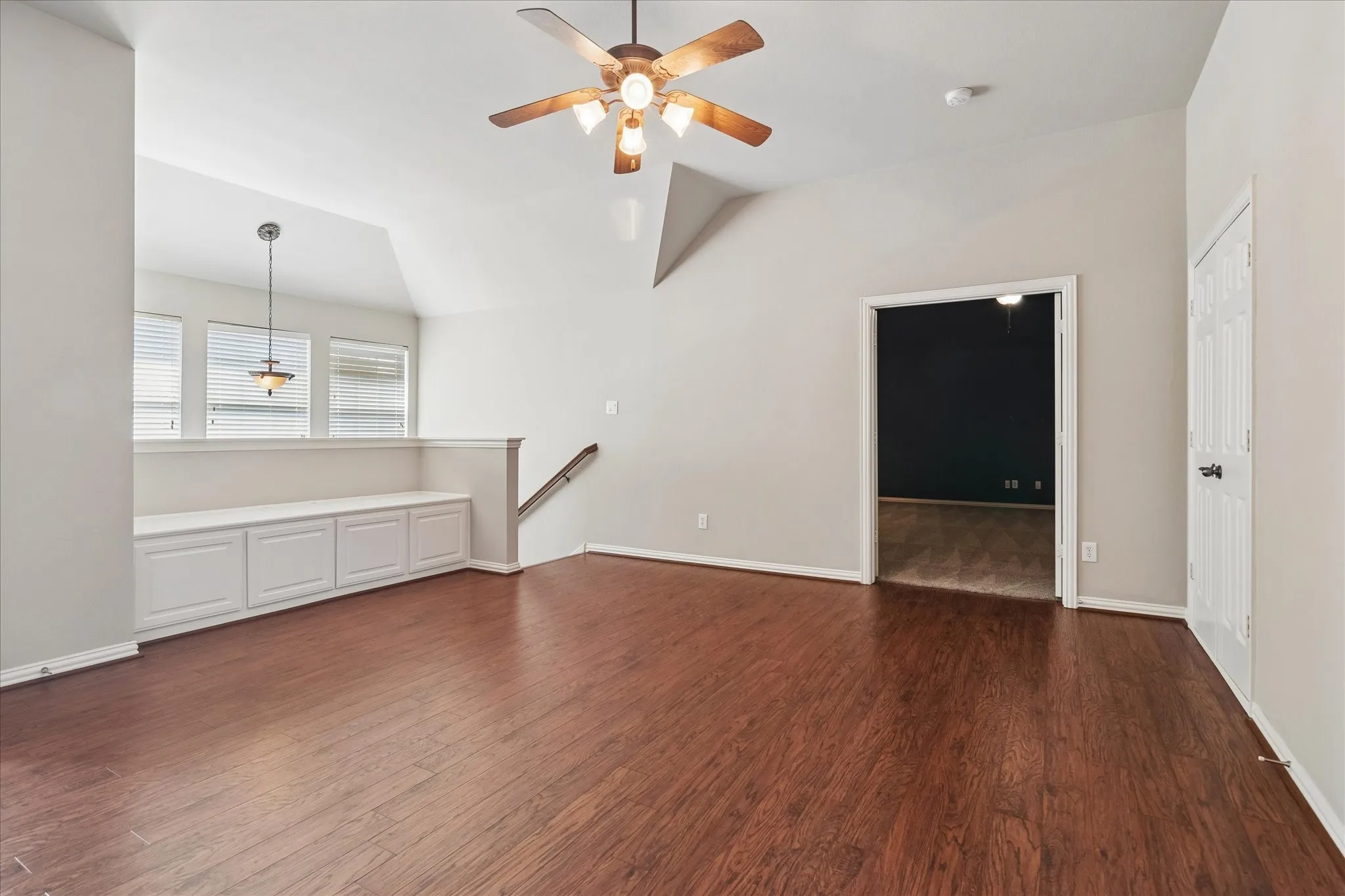 Wood-finish flooring throughout, vaulted ceiling, and recessed lighting