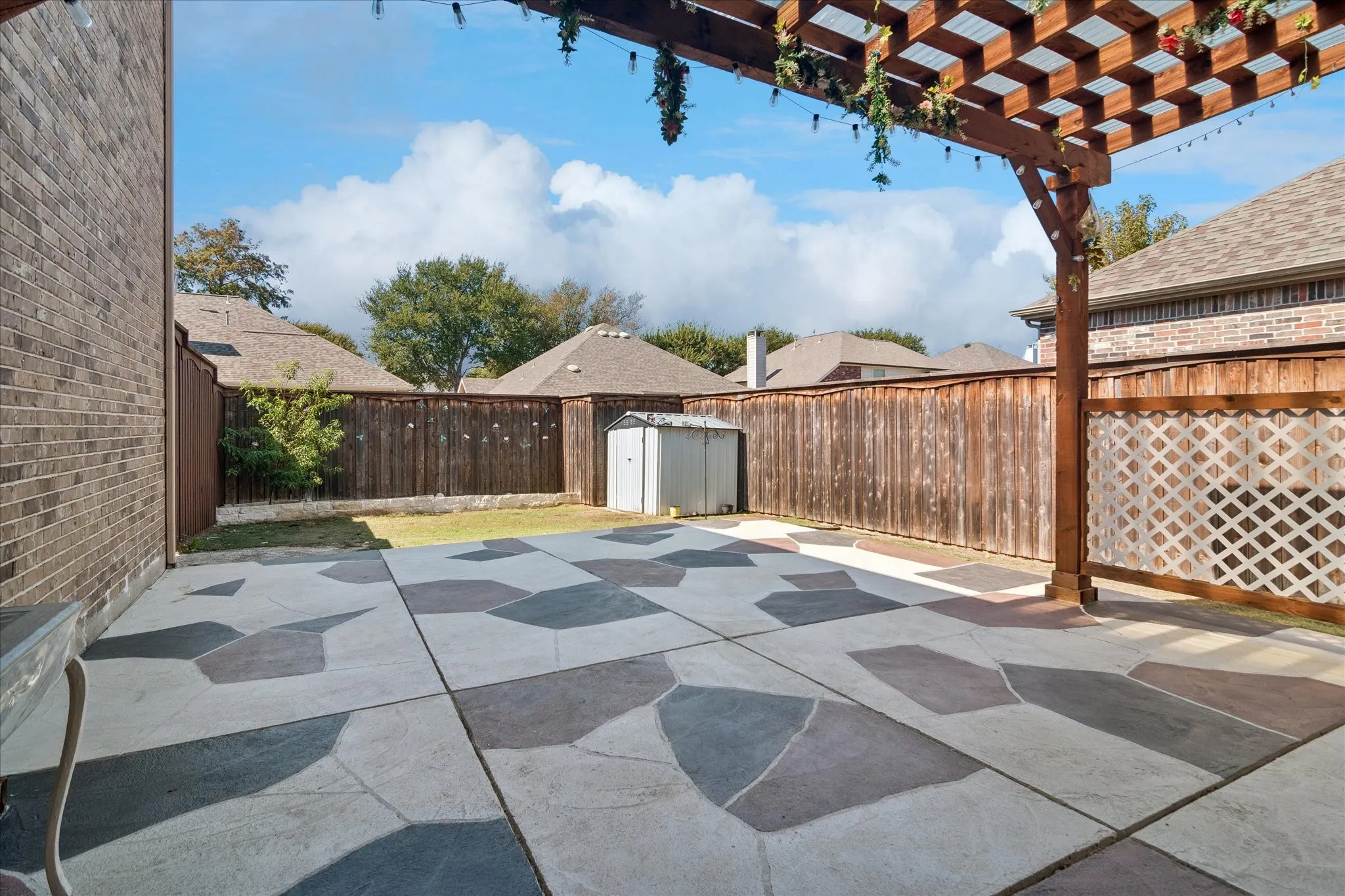 Custom-patterned concrete patio with a wooden pergola