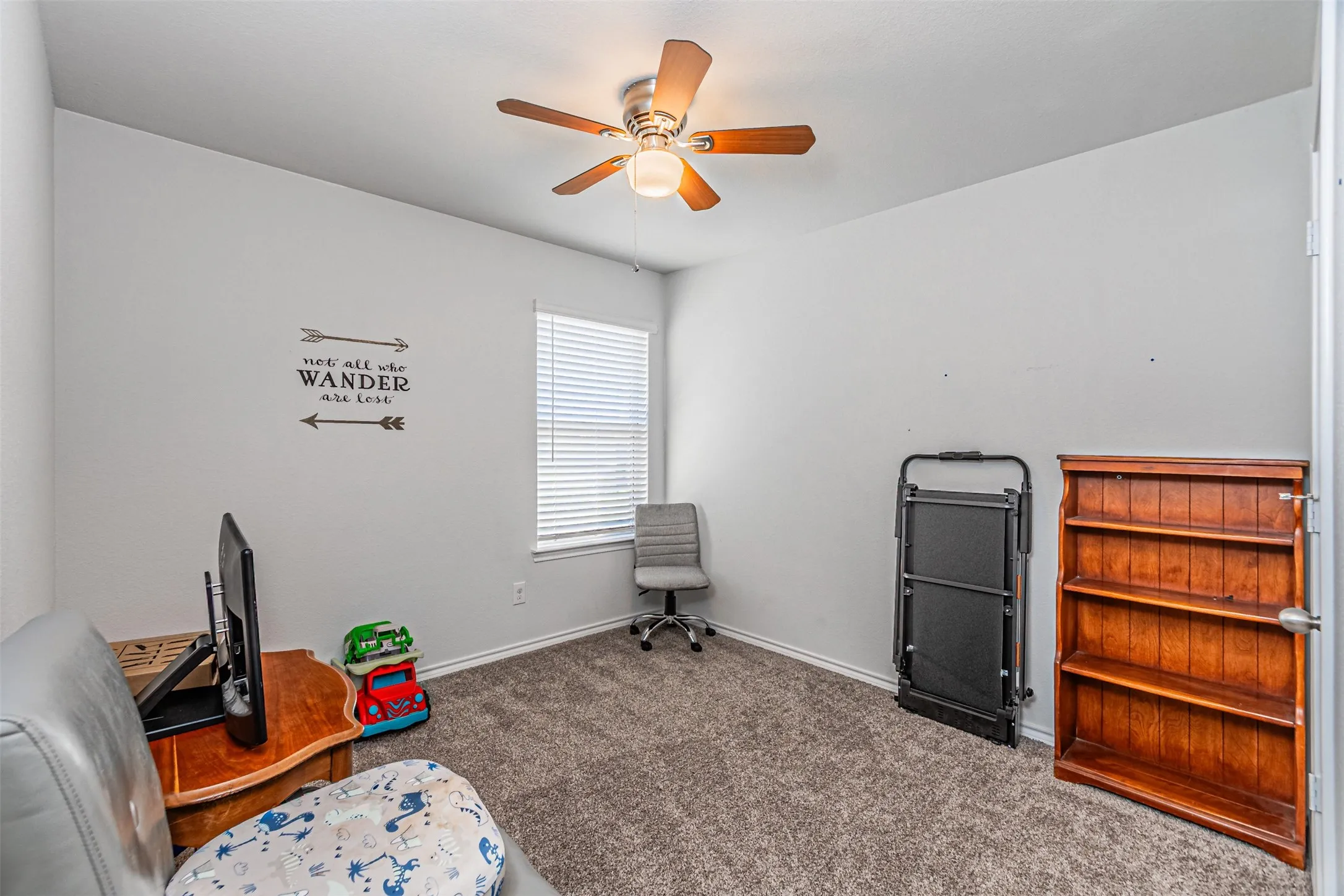 Carpeted room with a ceiling fan, a window with blinds, and light-toned walls