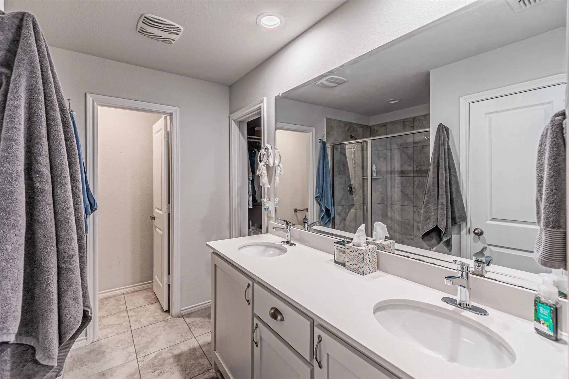 Dual vanity with undermount sinks, chrome fixtures, and light-toned countertops