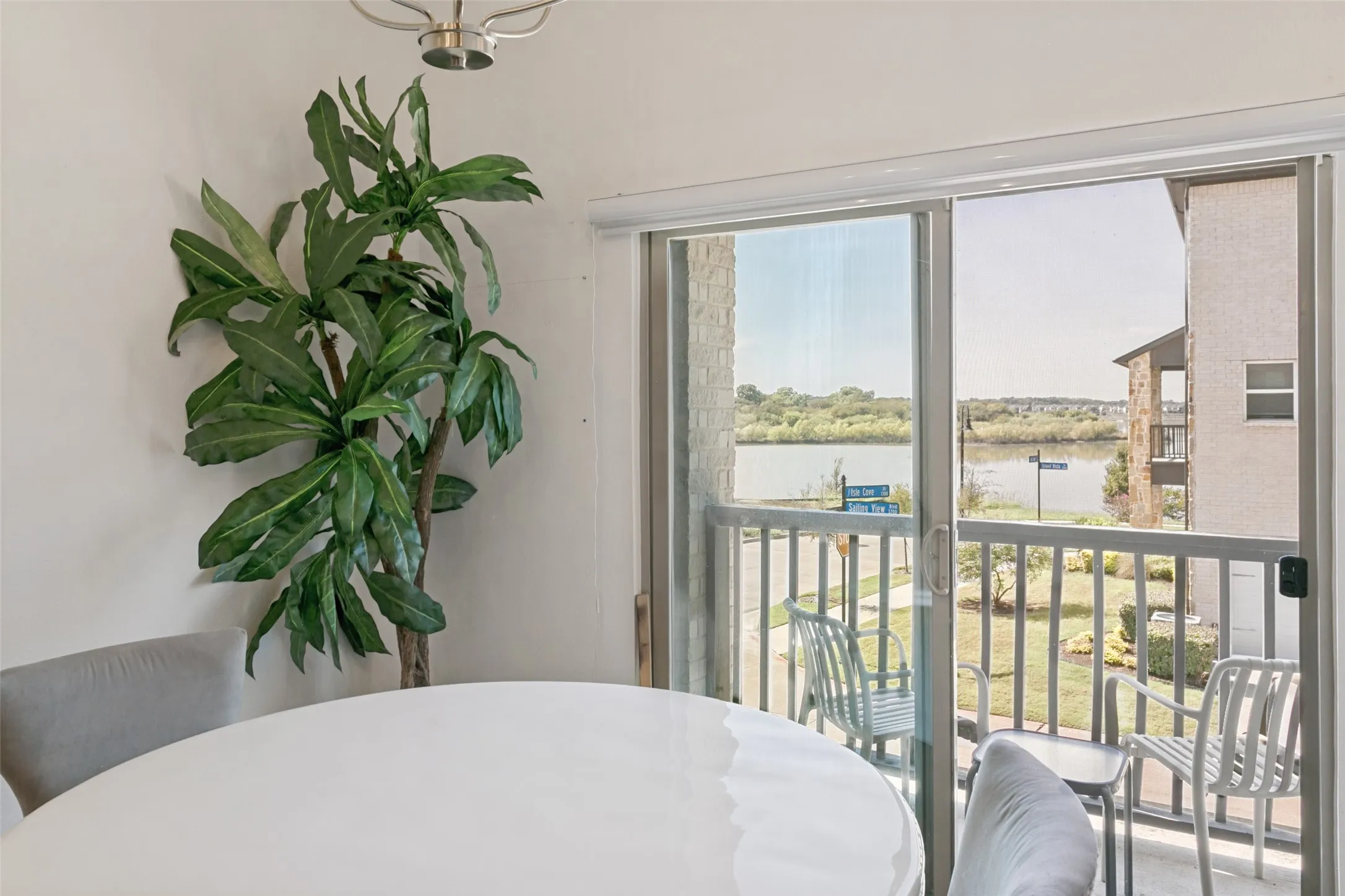 Sliding glass door leading to a balcony, offering expansive water scenery