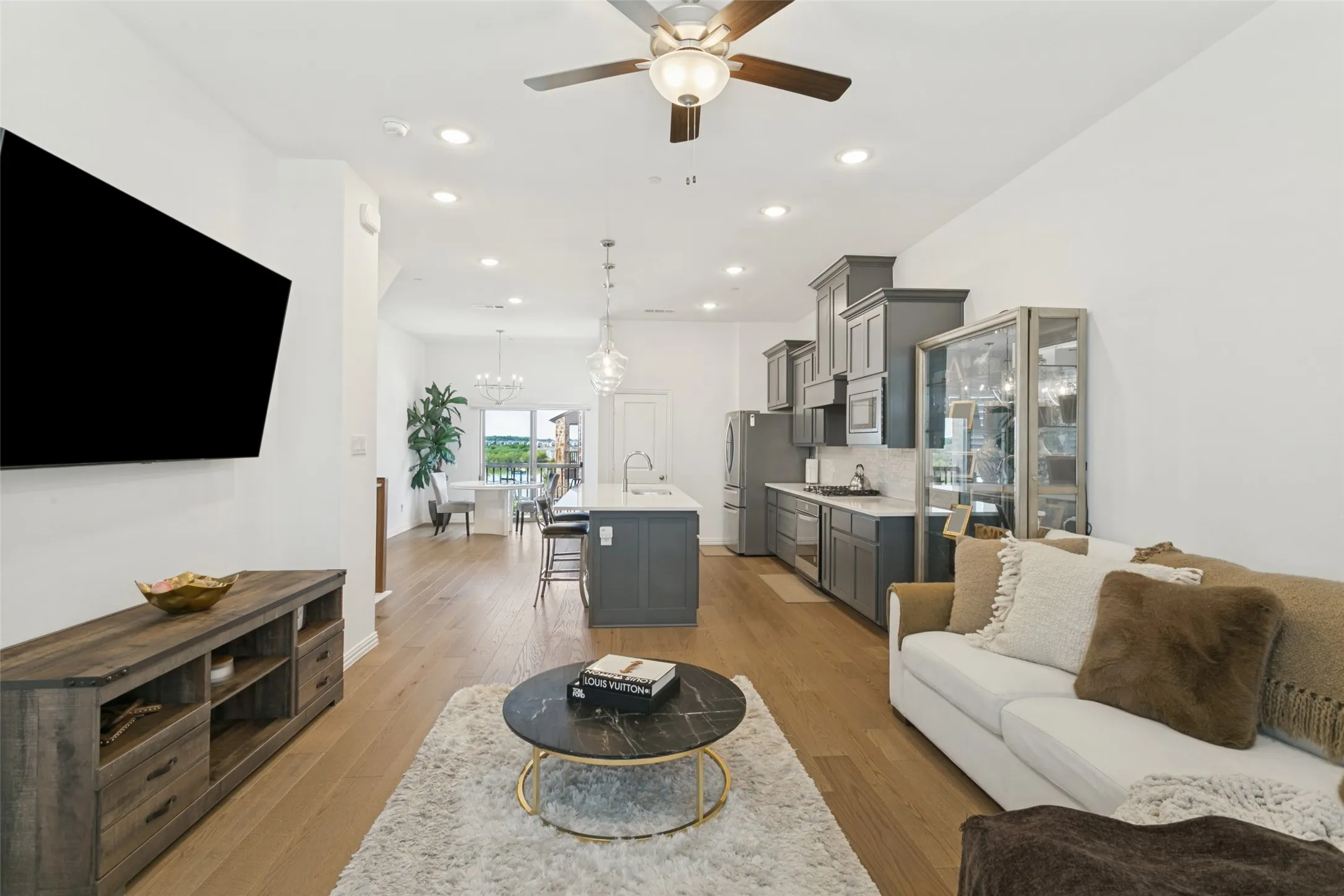 Open-concept living area with wood-finish flooring, recessed lighting, and a ceiling fan