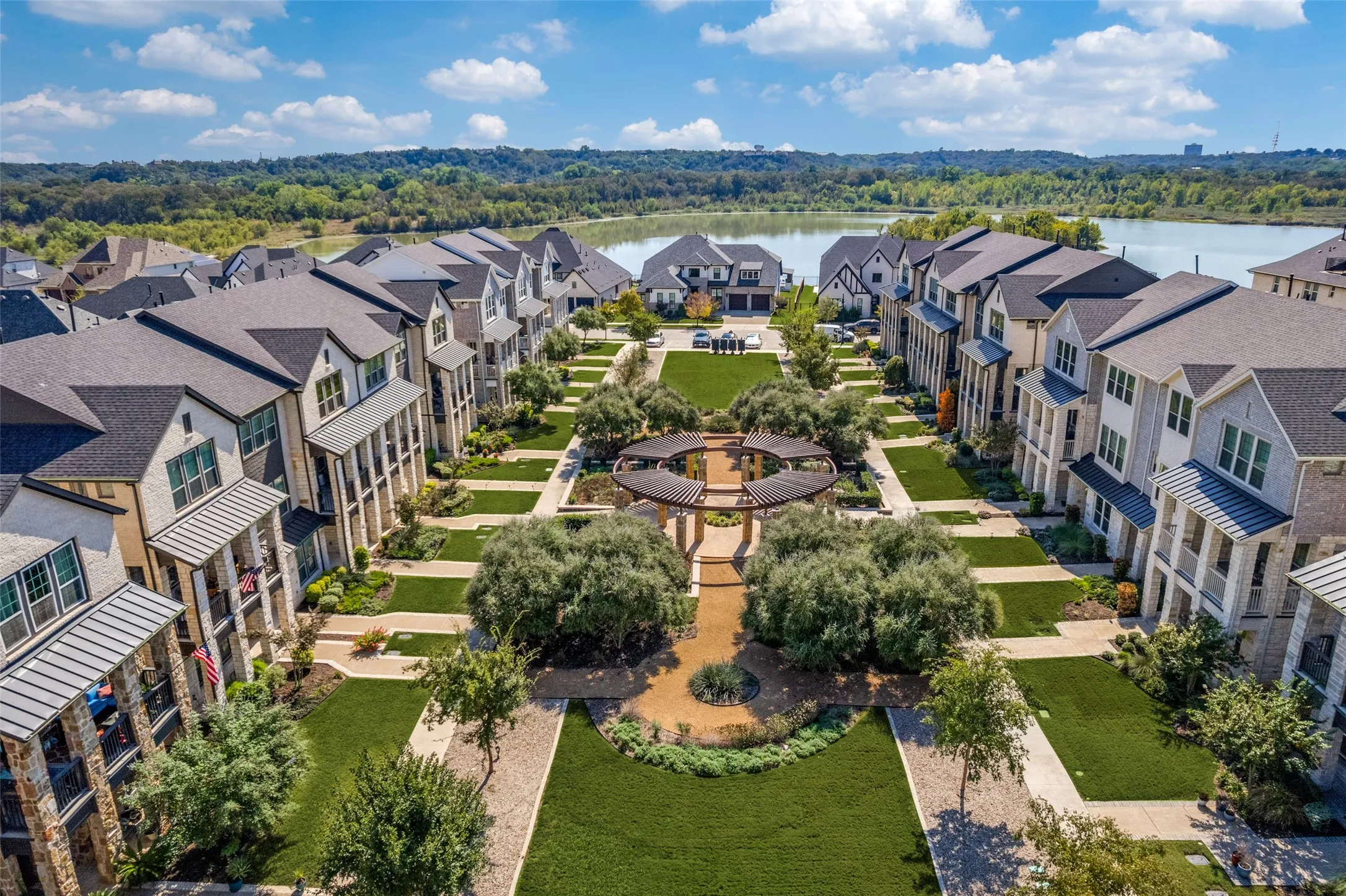Community green space with walking paths, mature landscaping, and a central circular pergola
