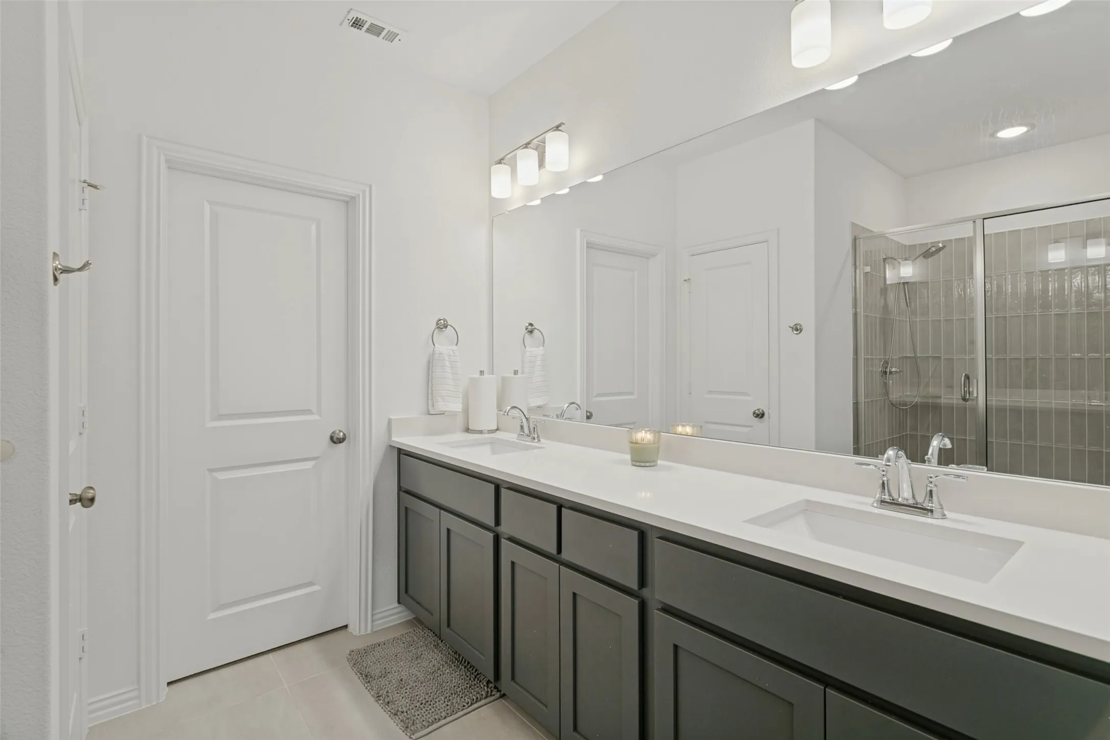 Dual vanity with dark wood-finish cabinetry, white countertops, and integrated sinks